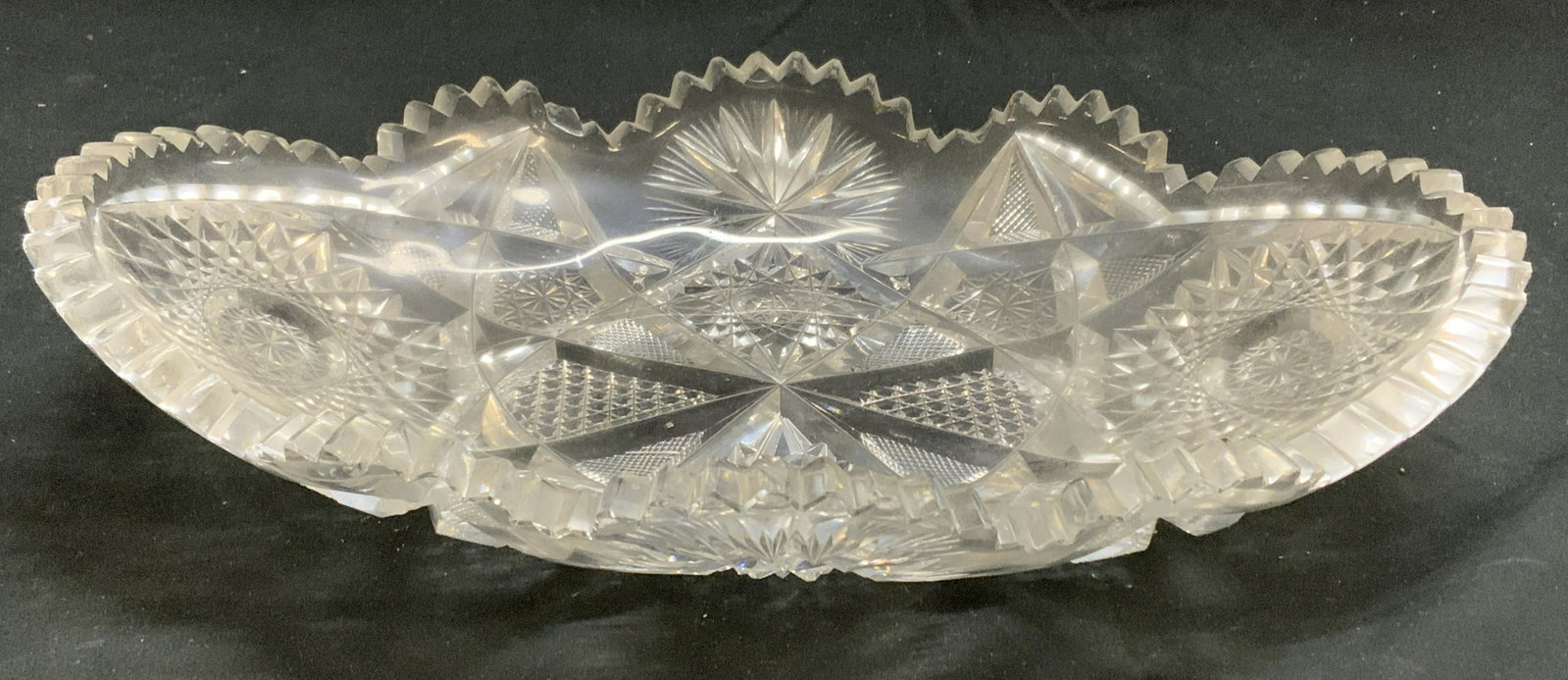 Thick Cut Glass Sawtooth Rim Dish: Thick cut glass dish with sawtooth rim. Measures approx. 11.75 x 7.75 inches. Surface wear consistent with exposure. Glass dish, cut glass dish, sawtooth rim dish, Glass dish, tableware, table decor, 