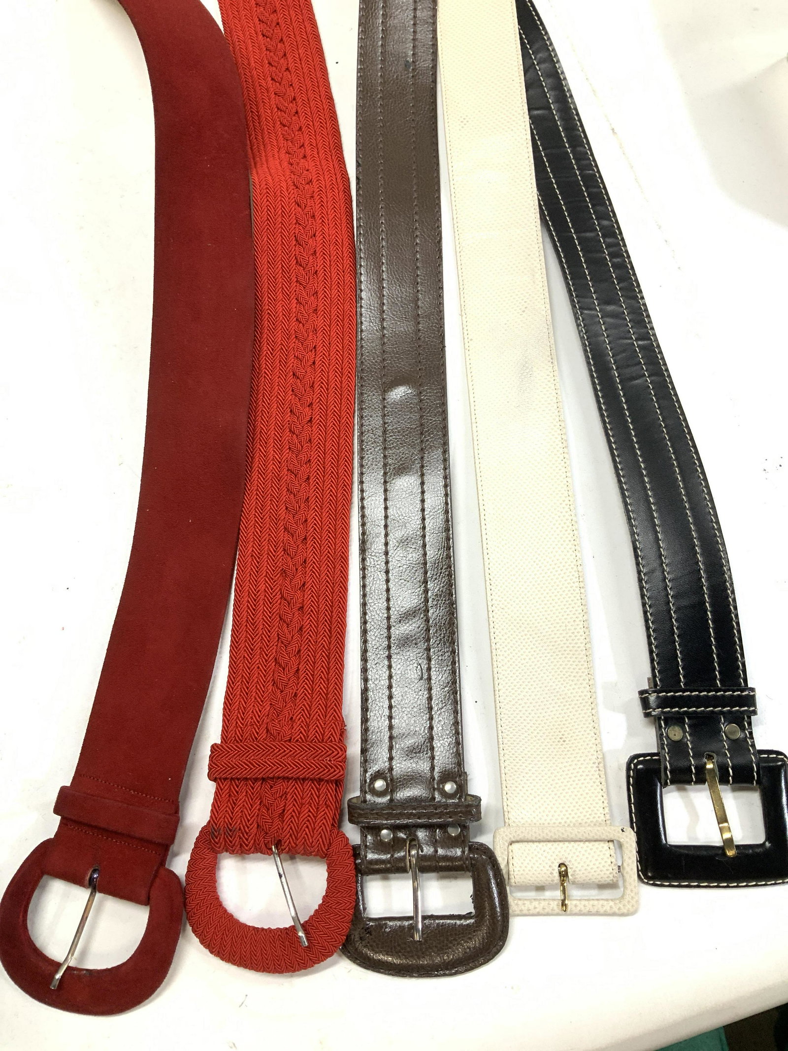 Lot 5 Leather & Suede Ladies Belts: 3 leather belts ( thought to be leather, not labeled as genuine leather), one is white reptile leather. All buckle belts with prong holes. Black leather belt with white stitching, 34 in. x 1.75 in. Wh