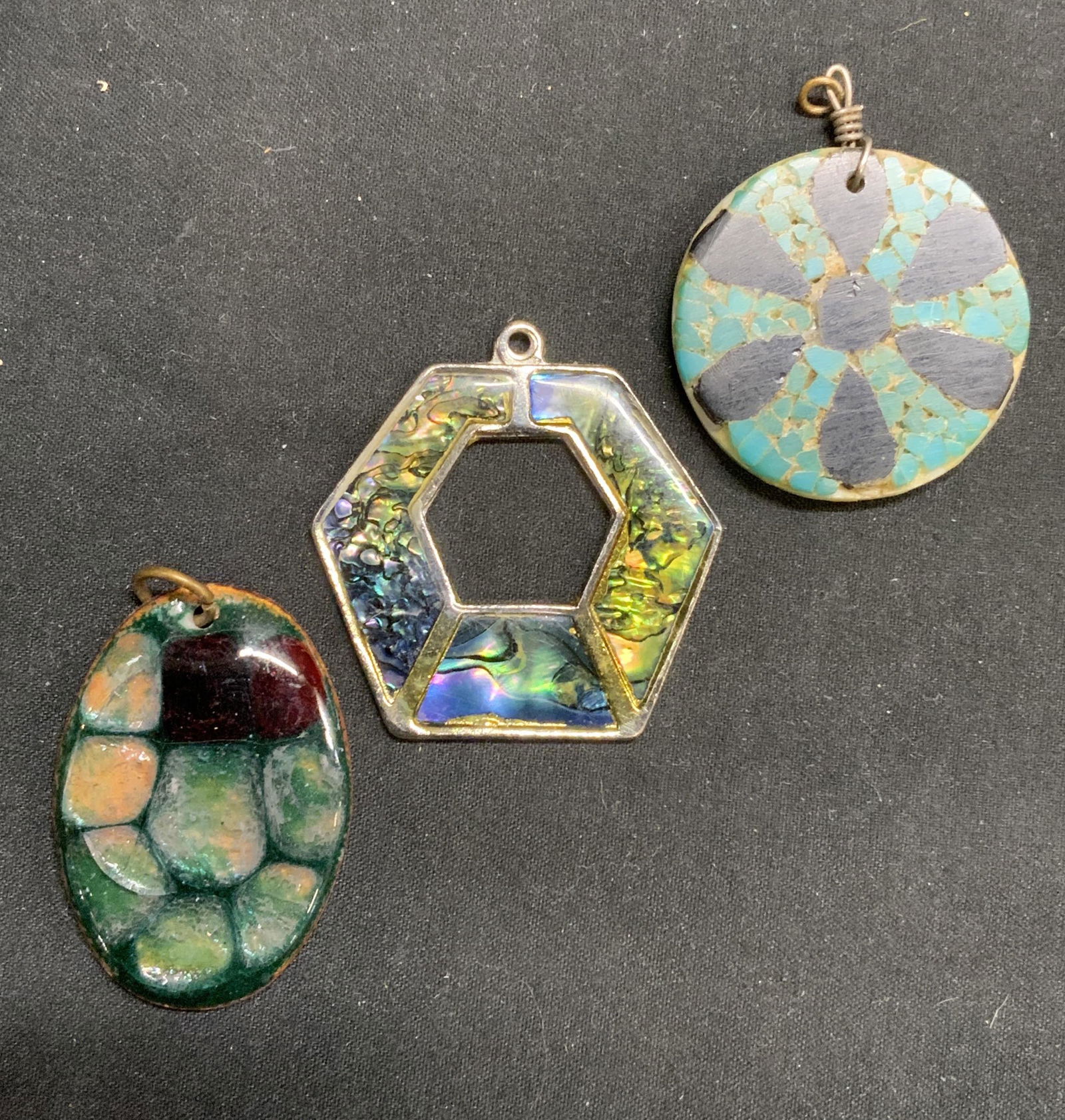 Lot 3 Glass & Enameled Pendants, Jewelry Making: Lot of 3 glass and enameled Metal pendants. 1 round floral motif pendant with glass mosaic decoration in hues of turquoise, black, and white, measures approx. 1.25 inches diameter. 1 open geometric sh