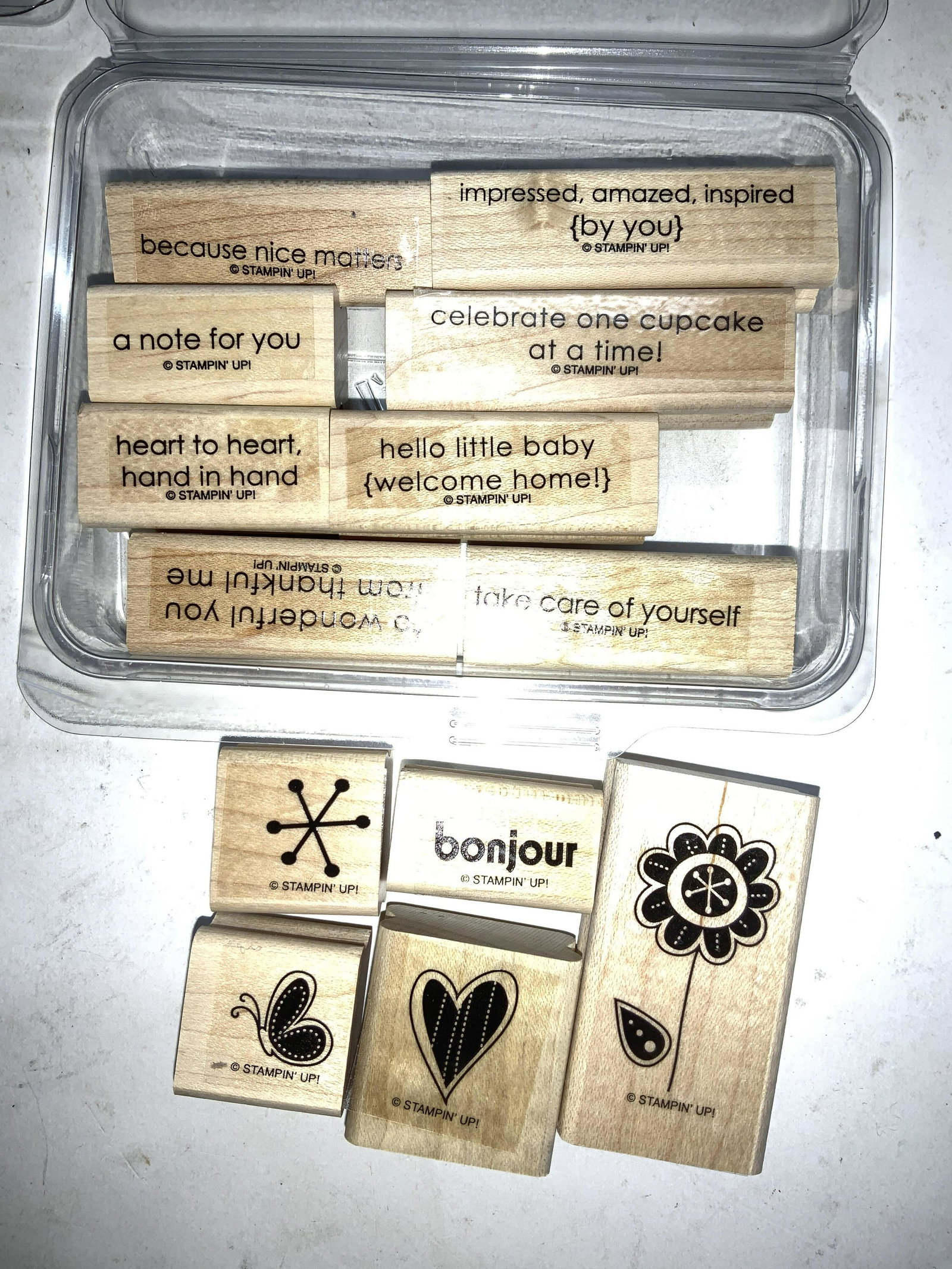 Lot 13 Arts and Crafts Stamps, New: Stampin Up craft and scrap booking stamps with images of flower, Heart, Butterfly, jack, and other stamps with messages like Bonjour, Take Care of Yourself, Hello Little Baby Welcome Home, etc. larger