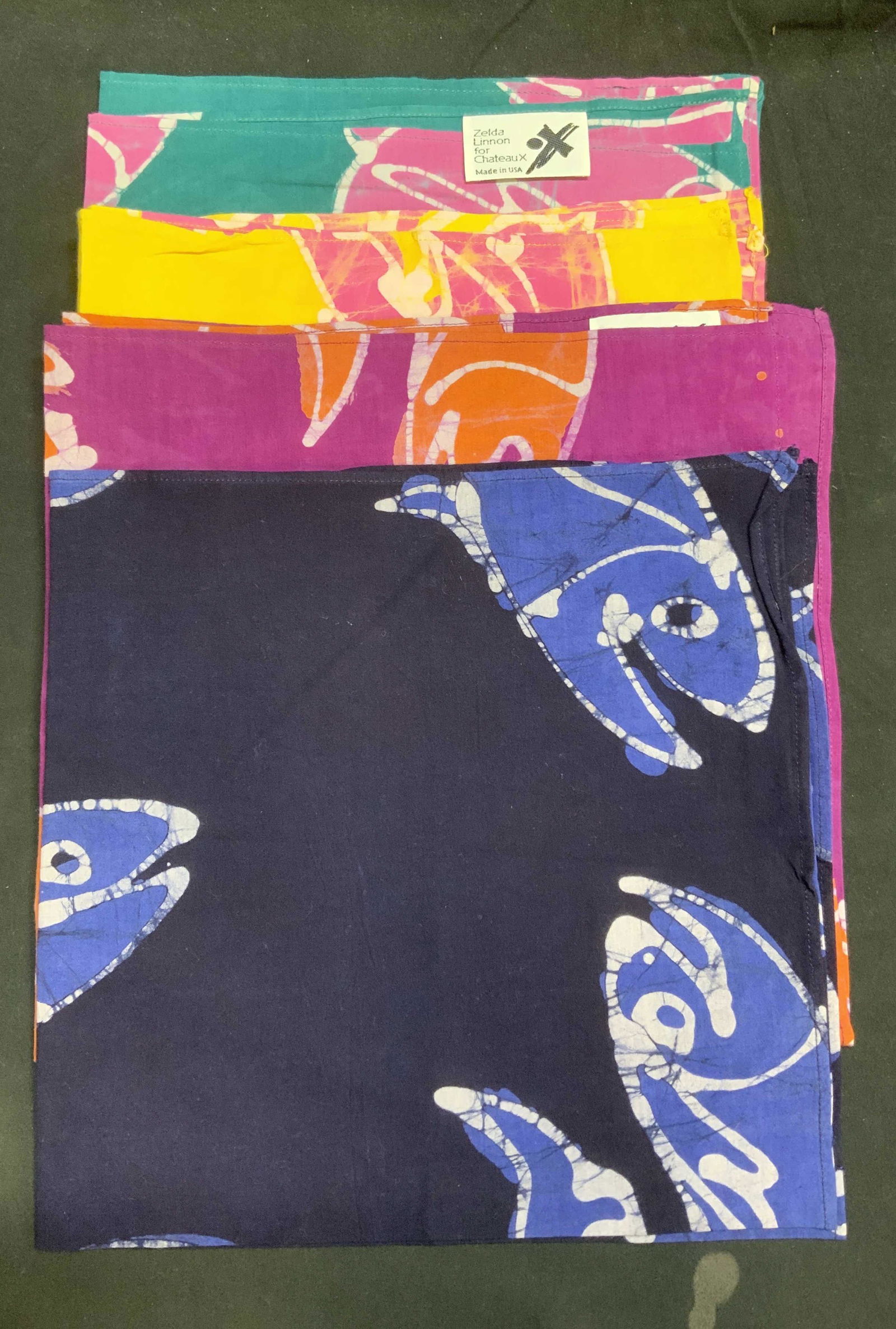 Set 4 ZELDA LINNON FOR CHATEAUX Fish Napkins: Set of 4 4 multicolor cotton napkins by Zelda LINNON for Chateaux in hues of yellow, green, blue, and purple. Measure approx. 20.5 x 20 inches each. In good condition. Minor blemishes observed. Dinner