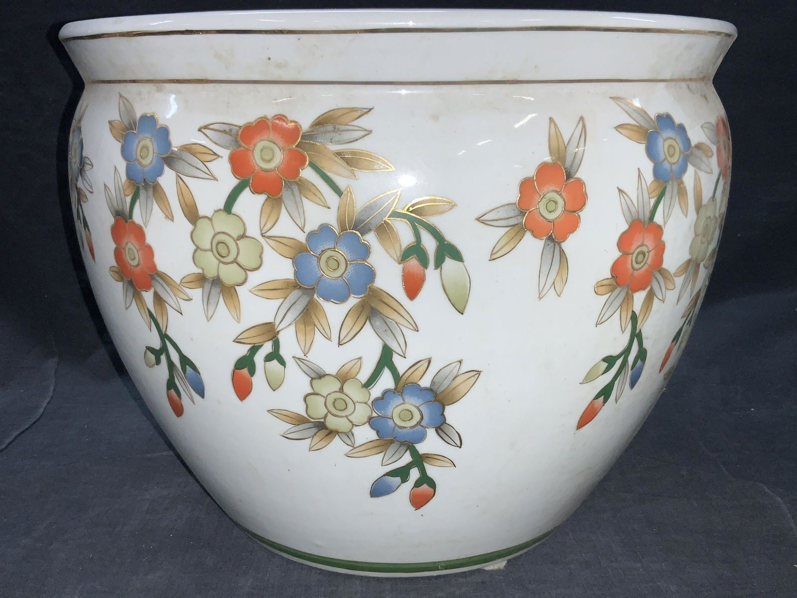White Porcelain Asian Style Vessel Planter: White Porcelain made vessel, exterior is adorn in painted blue and orange flowers with gilt outlines, rim of vessel has purple lotuses, interior of vessel has motifs of exotic gold fish amongst water