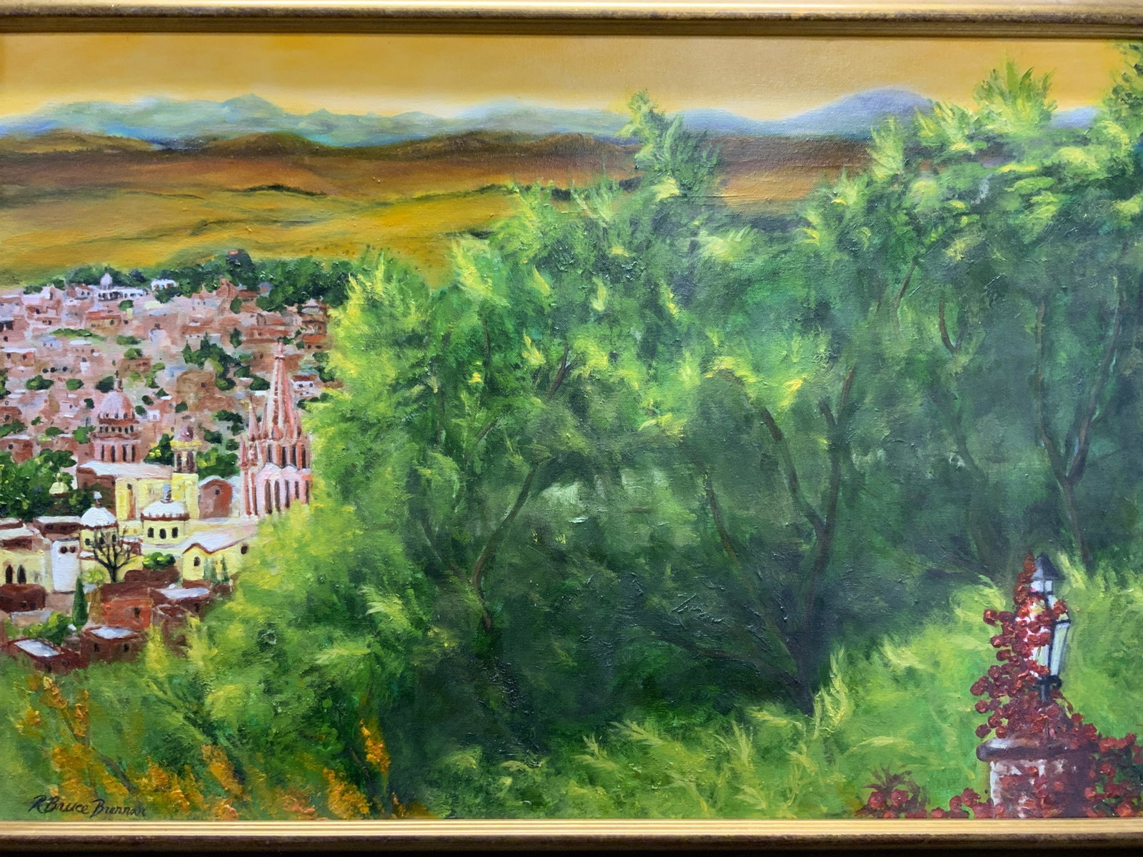 Signed R BRUCE BRENNAN Landscape Oil Painting: Framed R Bruce Brennan oil on canvas painting. Signed to lower left corner. Subject depicts a landscape in foreground with city in background. Loose brushstrokes in hues of green, red, and yellow. Pro