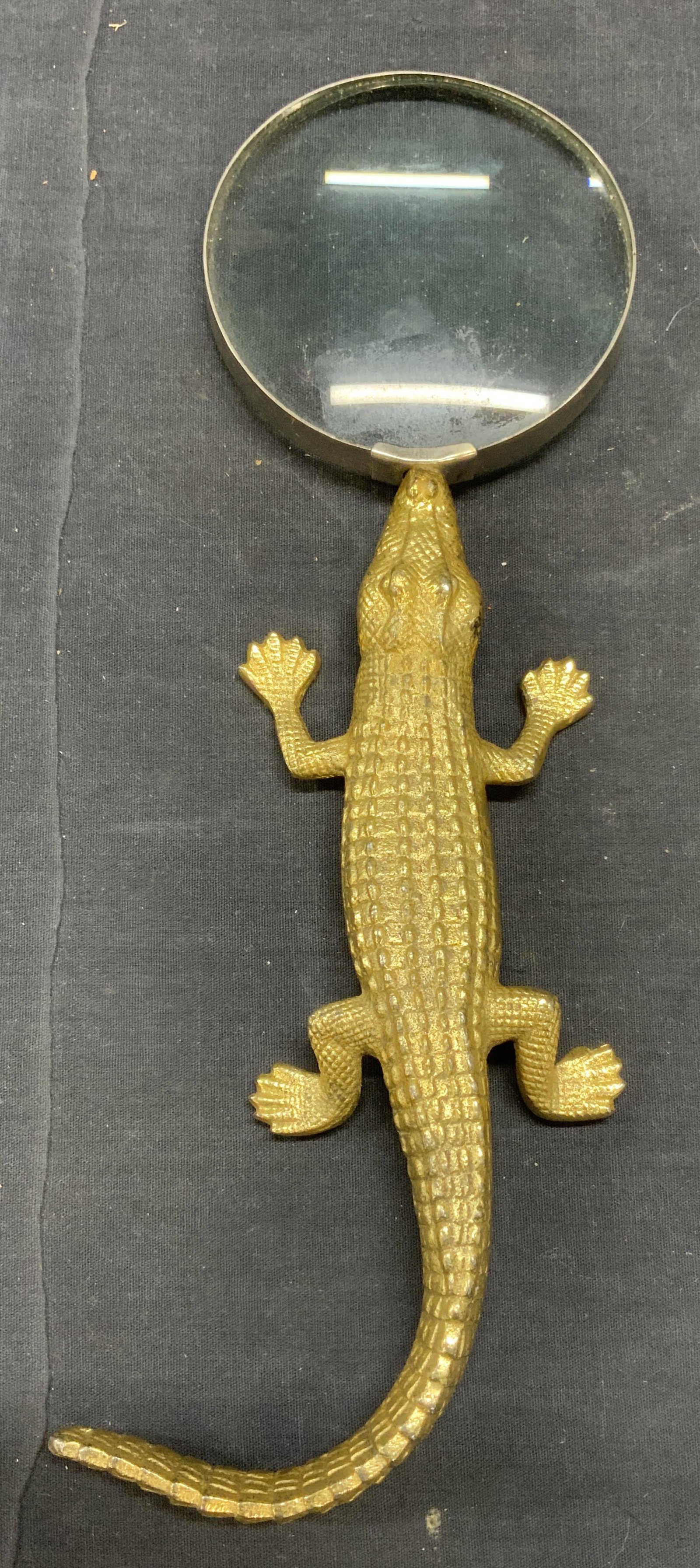 Gold Tone Crocodile Magnifying Glass: Magnifying glass with gold tone crocodile form handle. Surface wear consistent with exposure. Measures approx. 5 inches wide and 13 inches long. Property of Palm Beach, Florida Estate. Magnifying glas