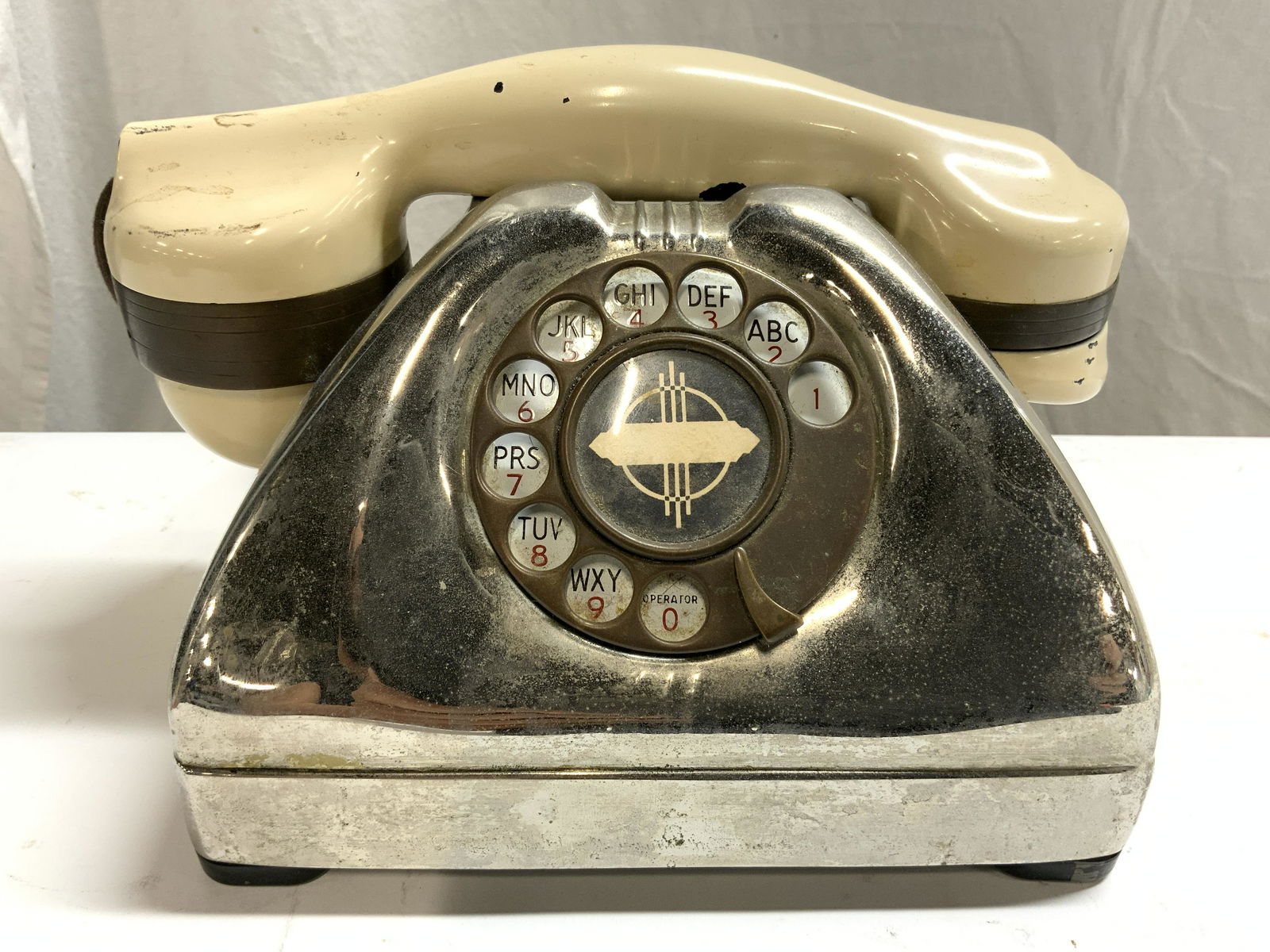 TP 6 A Vintage Metal Rotary Dial Telephone: Underside reads TP 6 A. Telephone is vintage. Piece is silver toned and metal with tan toned receiver. Phone has rotary dial. Phone measures approx 9 inches long 5.5 inches tall 5 inches deep. Telepho