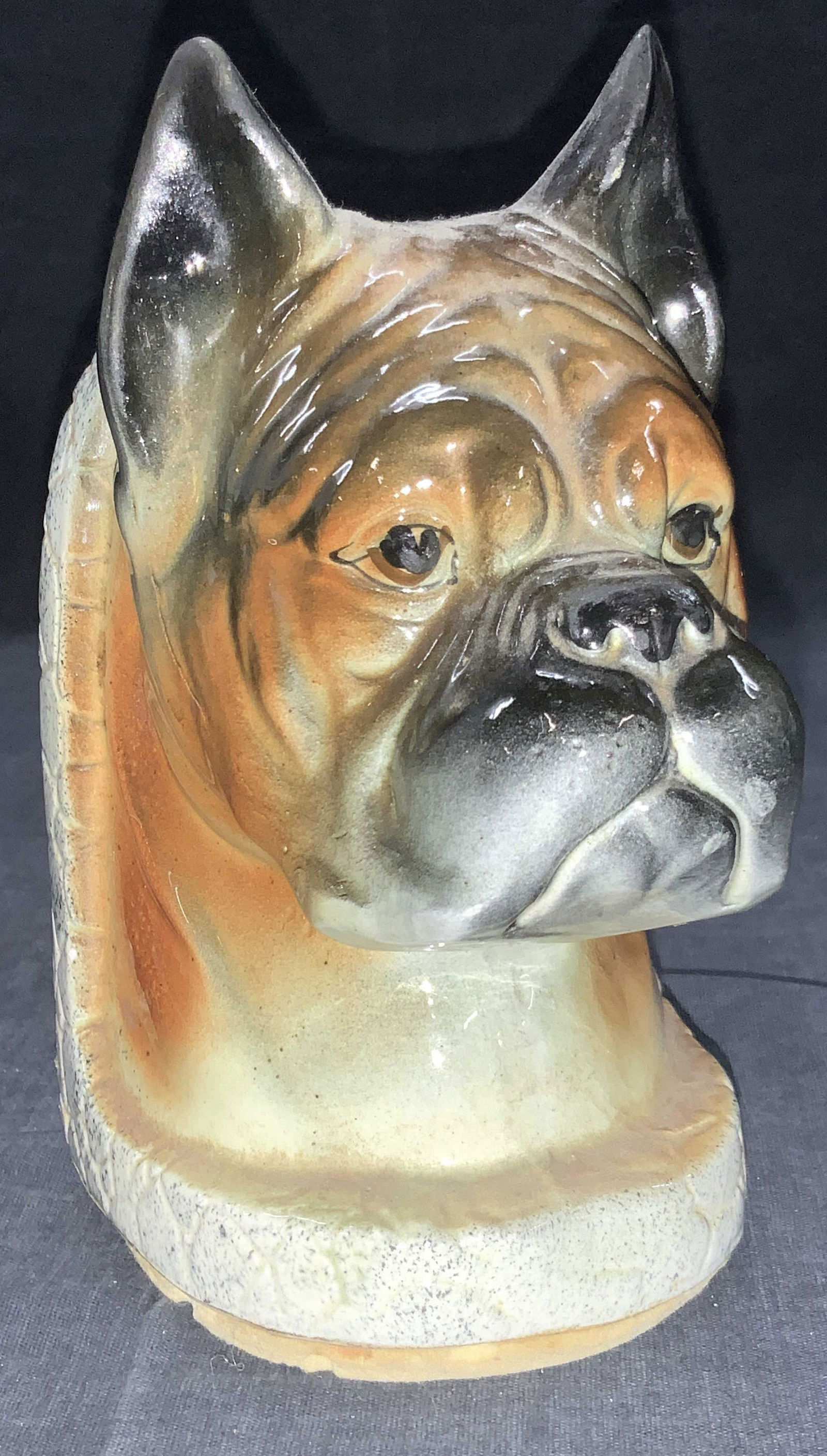 Ceramic Made Boxer Dog Bookend: Ceramic made Boxer Bookend with the head of a Boxer complete with pointed ears. Corked underside holds rice. Approximately 6.5 inches tall and 3 inches wide. Minor wearing to ceramics due to age ad us