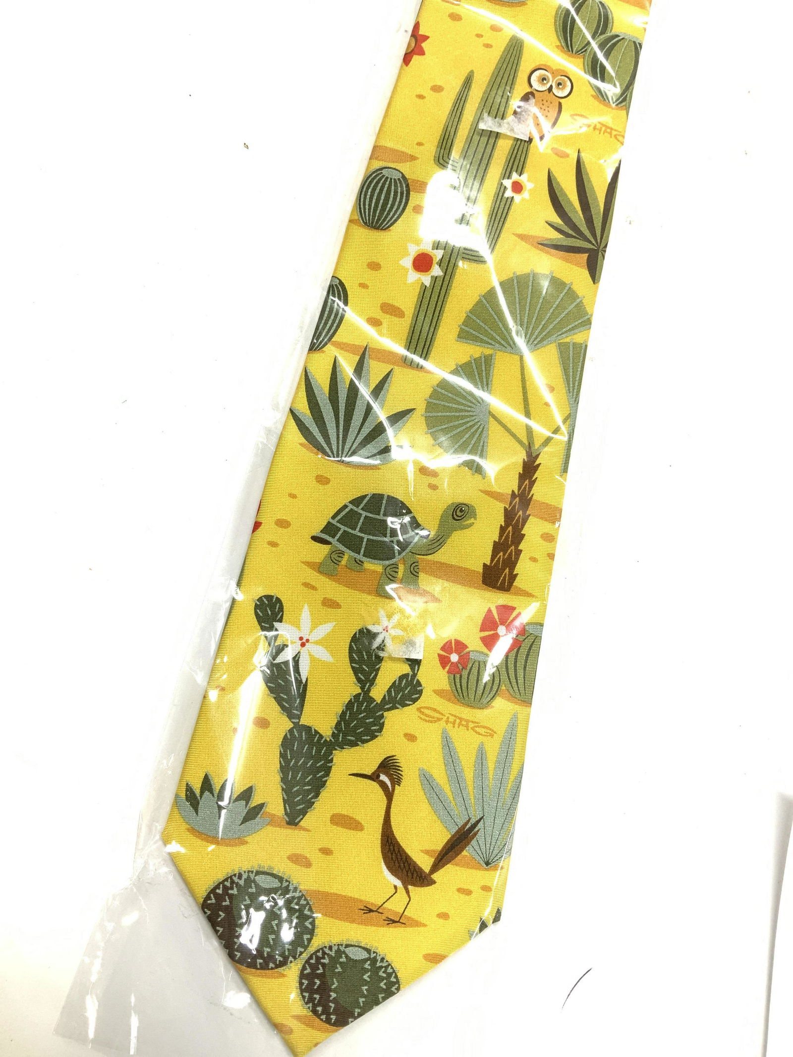Signed SHAG Store Desert Cacti Motif Silk Tie, NIP: Fun fashion cocktail tie from the hip Shag Store Palm Springs/ West Hollywood. 100% Silk. Labeled designer. Signed Shag. Bright yellow with desert motif - flowering cacti, Prickly cactus, agave plant,