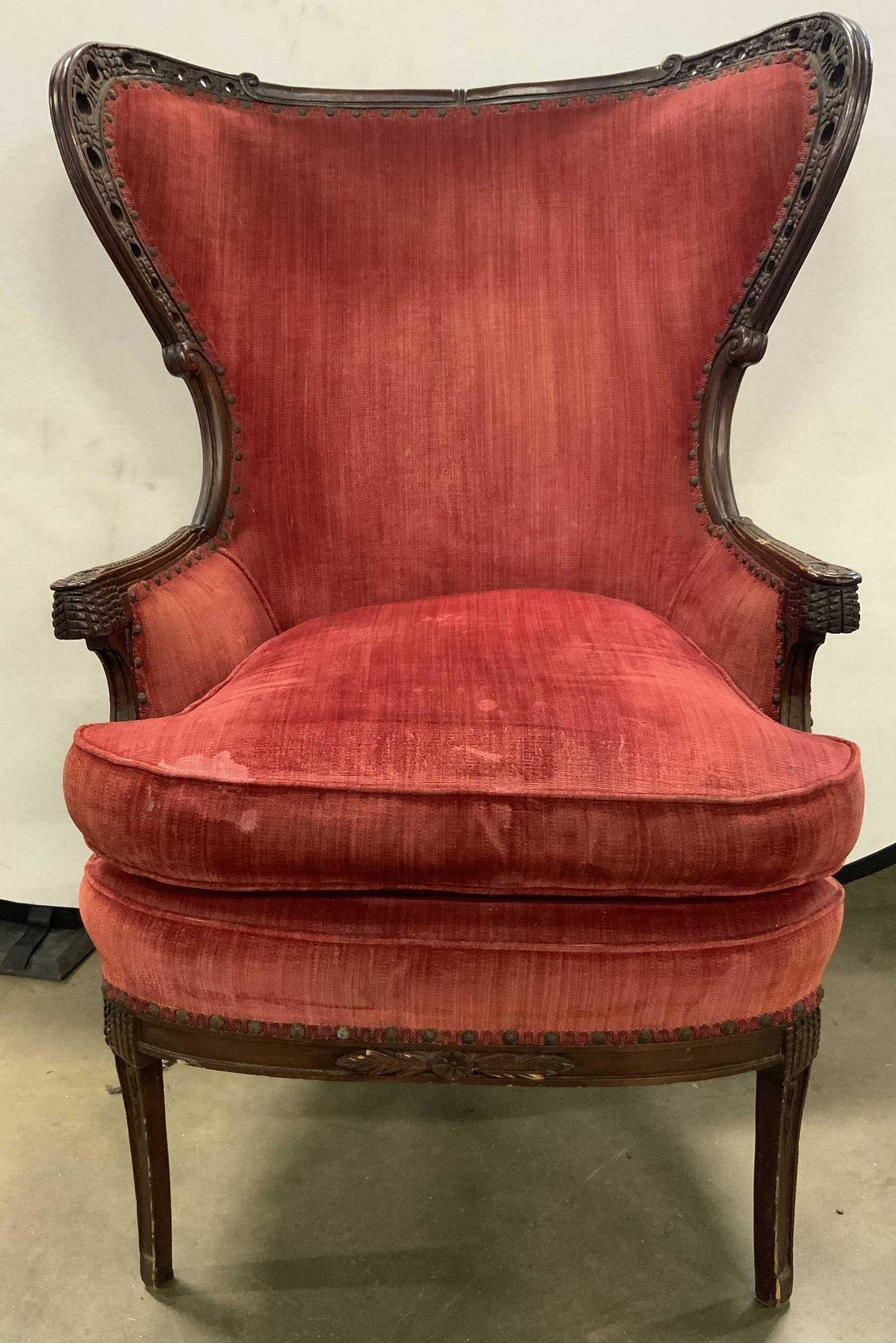 Vintage Carved Wood Frame Uph Wing Chair: Chair is vintage possibly antique. Piece has intricately carved wooden frame with pierced, floral, & leaf detail. Chair has carved scrolled detail. Chair has gimp, welting & nailhead detail edges to u