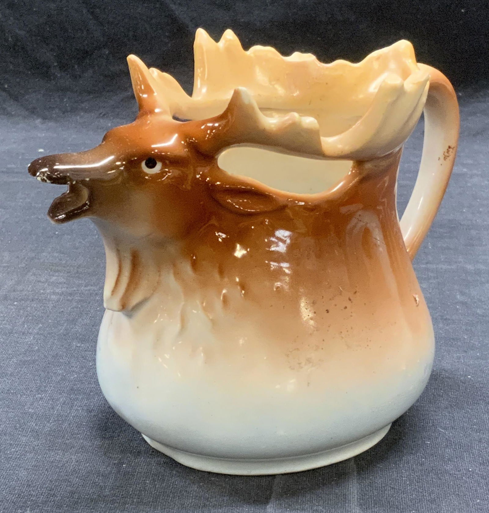 Vintage Porcelain Moose Creamer, Austria: Vintage porcelain moose form creamer. Marked Austria to underside. Chipping to antlers observed. Measures approx. 5.75 x 3.25 x 4.25 inches. Property of Palm Beach, Florida Estate. Porcelain creamer,
