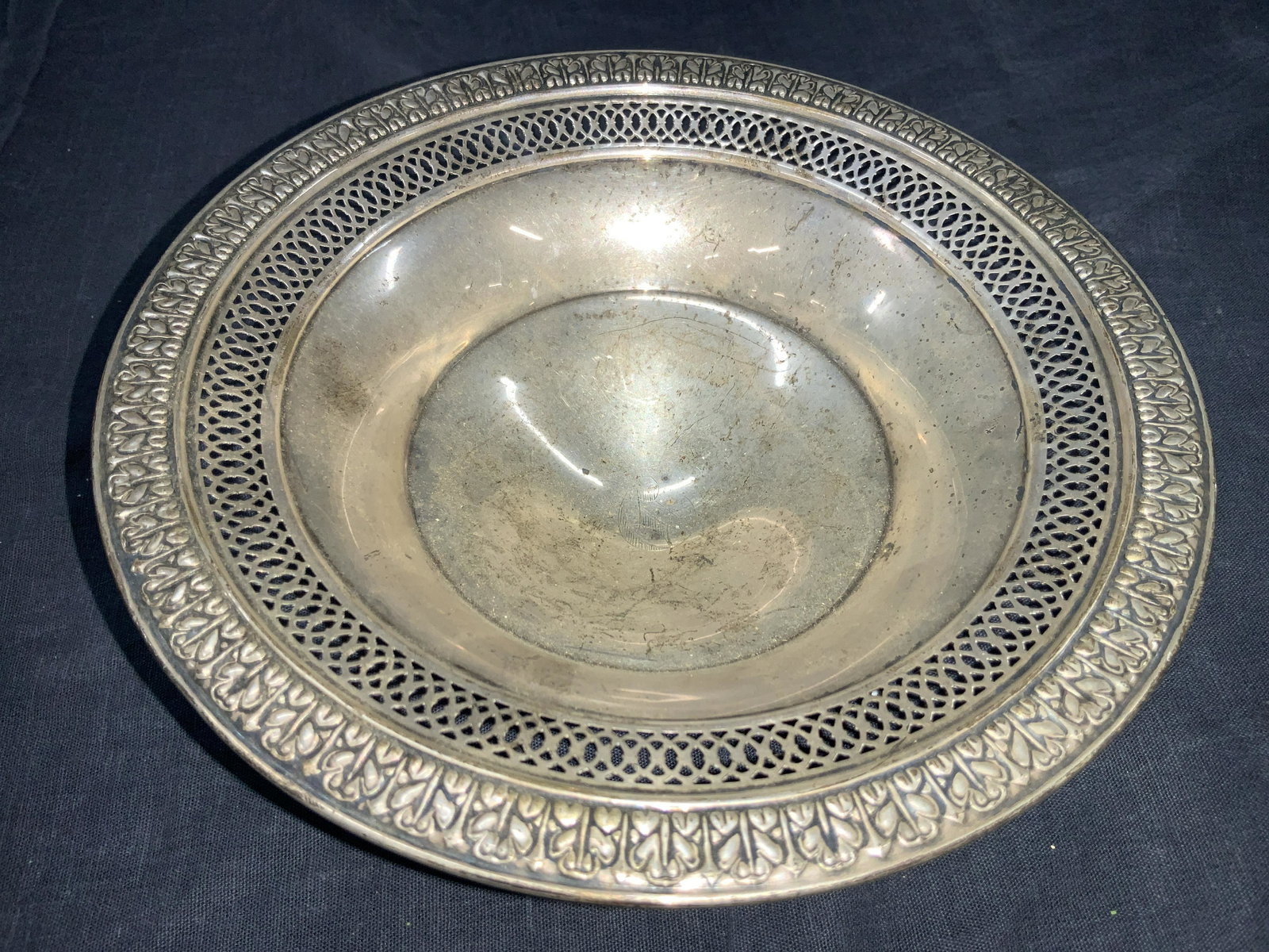 JW Hallmarked Sterling Footed Vessel: Hallmarked on undersides JW, Sterling, Reinforced with cement. Footer shallow bowl with embossed edges with scroll pattern with cut out patterned inner edges. Approximately 2.5 inches tall and 7.25 in