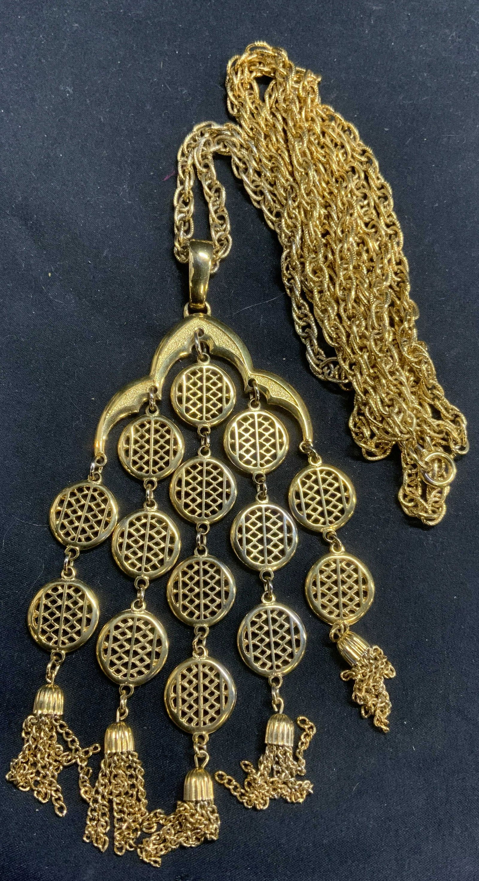 TRIFARI Gold Tn Double Chain Pendant Necklace: Trifari gold tone double chain pendant necklace. Designer label to underside of pendant. Measures approx. 32 inches long. Pendant measures approx. 2.75 x 5 inches. In good condition. Property of Palm