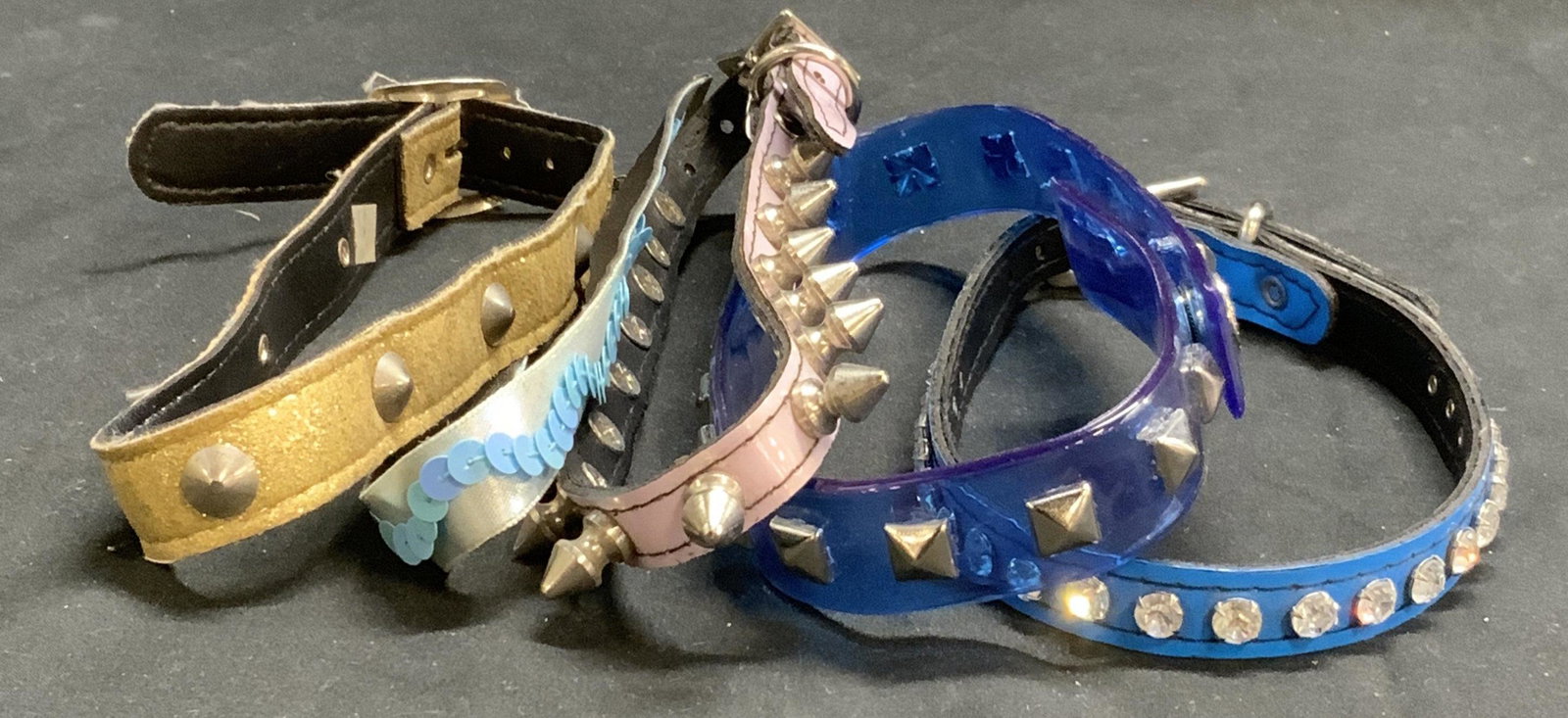 Lot 5 COSMIC GIRLS & More Studded Collar Necklace: Lot of 5 studded and sequin collar/choker necklaces. Transparent blue stud necklace labeled Cosmic Girls, approx. 16 inches long. Also includes pink spike necklace (18 inches long), shimmery gold stud