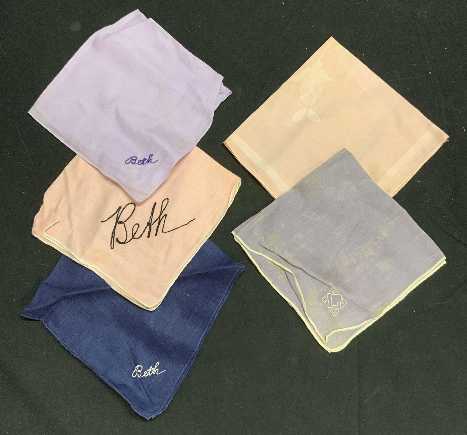 Lot 5 Vintage Embroidered Handkerchief: Lot of 5 vintage embroidered handkerchiefs in blue, purple, and pink. 3 pieces embroidered Beth, 1 embroidered with intuition C, 1 with floral motif. 4 pieces measure approx. 12 x 12 inches, C handker