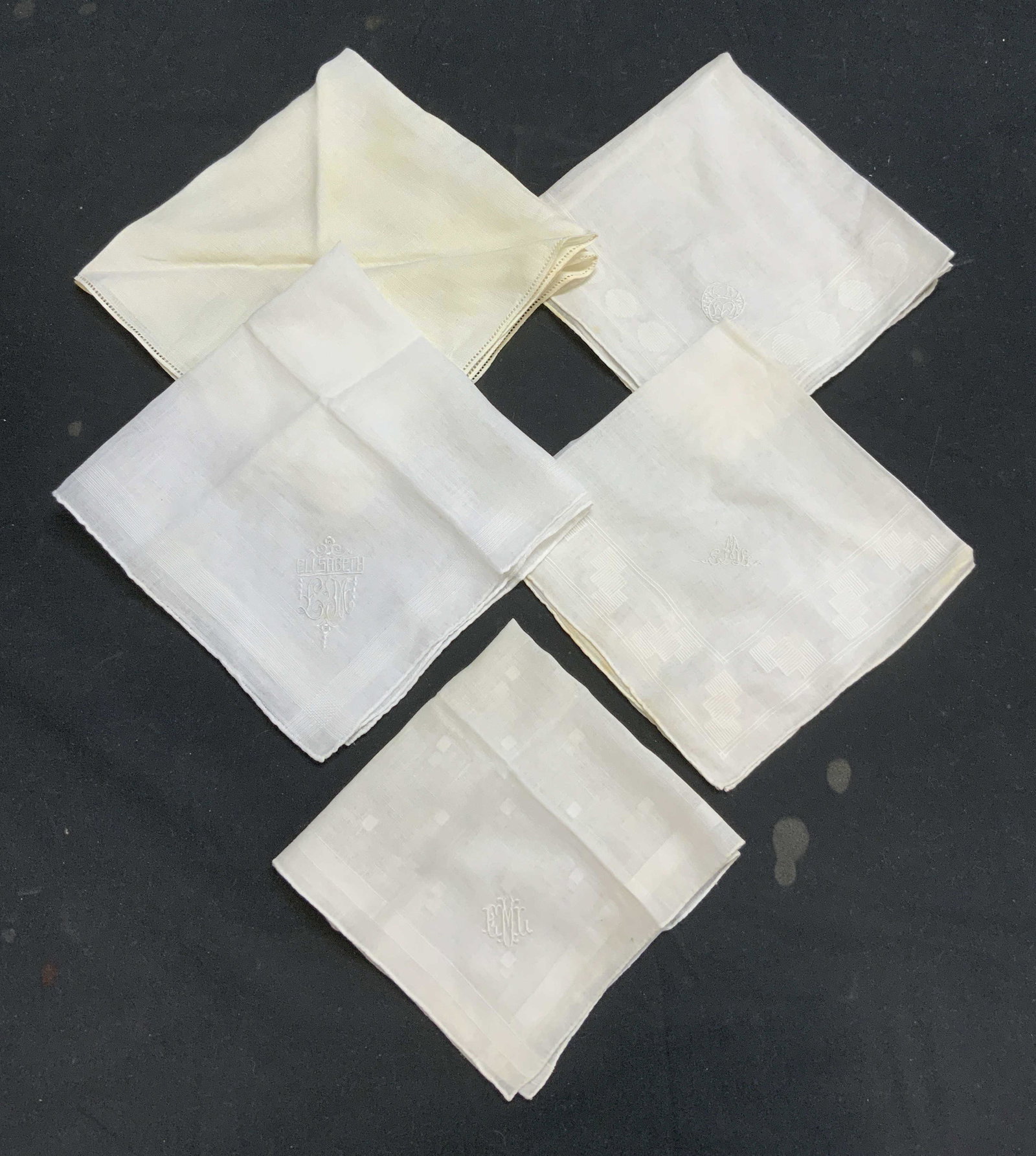 Lot 5 White Monogram Handkerchiefs: Lot of 5 white handkerchiefs. 4 with monogram embroidery. Monogram ELM. 1 handkerchief with Elisabeth LM embroidery. Largest measures approx. 13.75 x 13.75 inches. Smallest measures approx. 10.5 x 10