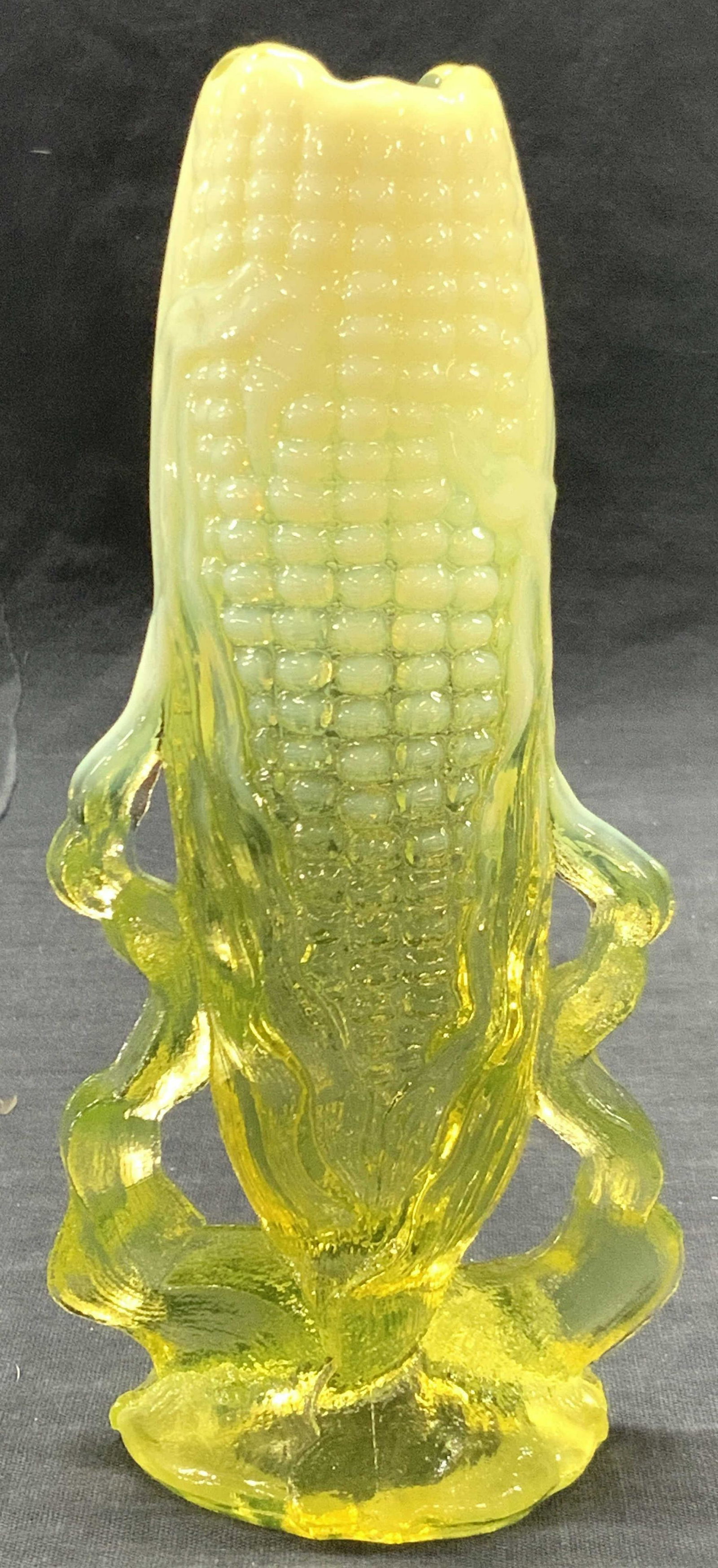 Art Glass Corn Cob Vessel: Art glass vase made to resemble a standing corn cob in two toned yellows, opaque top half and see throughout base. Approximately 7 inches tall. Evident loss to base. Art glass vase, glass vessel, corn