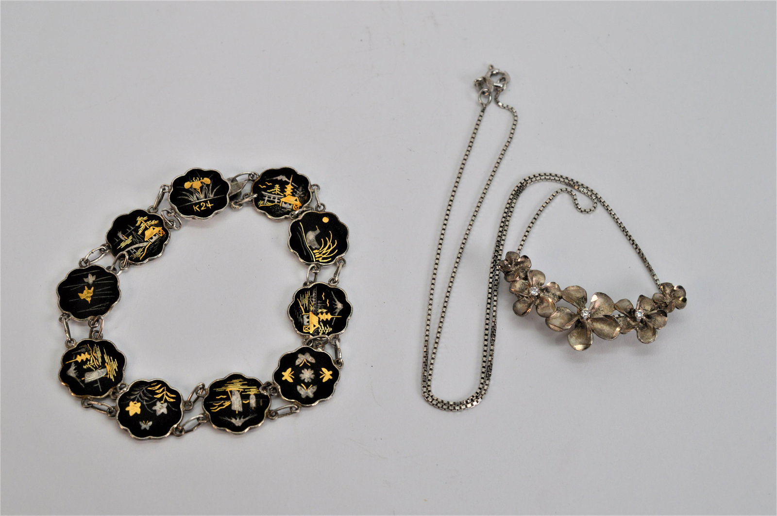 Ladies Vintage Necklace & Bracelet: Sterling silver 1MM 17 box chain has a sliding floral pendant with crystal detail. Post WWII Niello sterling silver panel bracelet was made in Japan. 24K gold etchings depict images of Japan. Bracelet