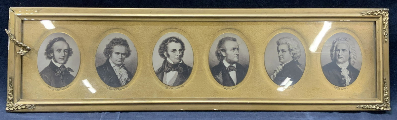 Giclee Portraits Of Classical Composers: A framed panel depicting various giclee prints of portraits of classical composers Mendelssohn, Beethoven, Schubert, Wagner, Mozart and Bach. All oval portraits surrounded by gold metal leafed backgro