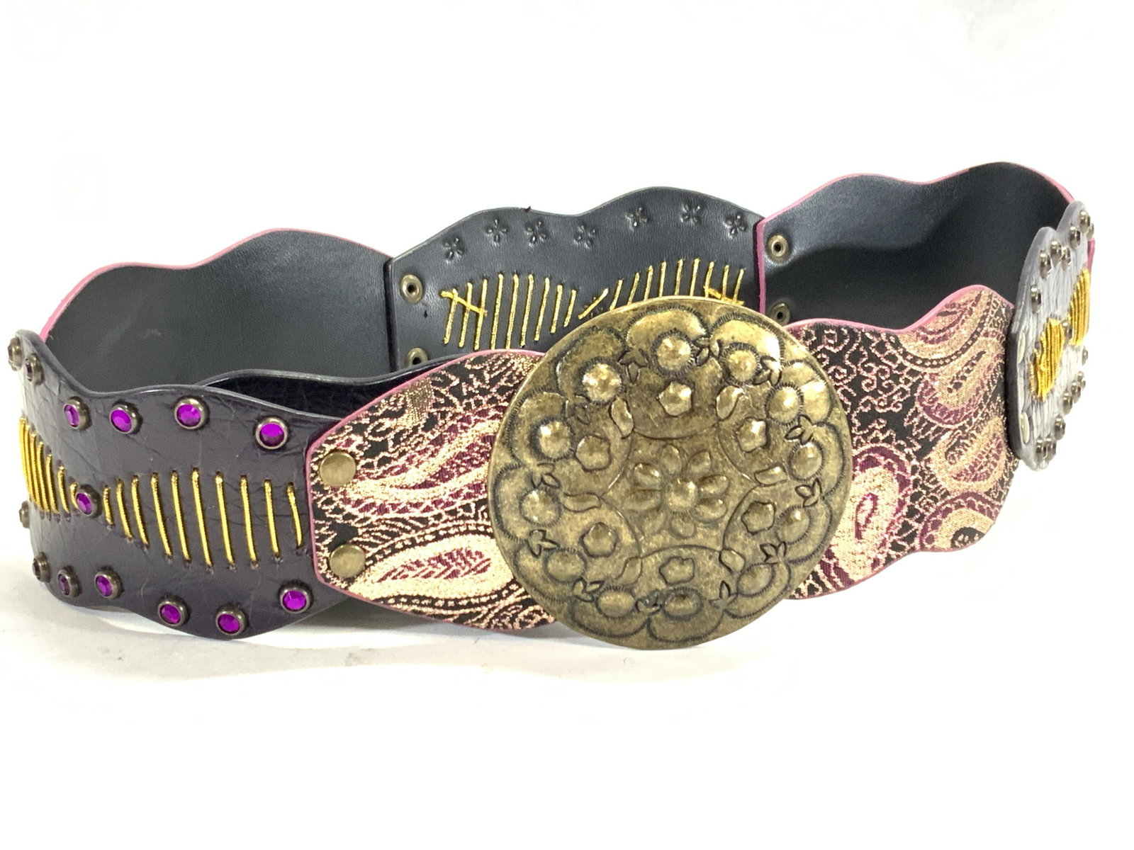 Faux Leather Bejeweled Costume Fashion Belt: Faux leather fashion belt with 3.75 inch hammered metal buckle. Belt is made of sections that are sewn with shimmering gold threading and bejeweled, and some with paisley patterns. Approximately 41.25