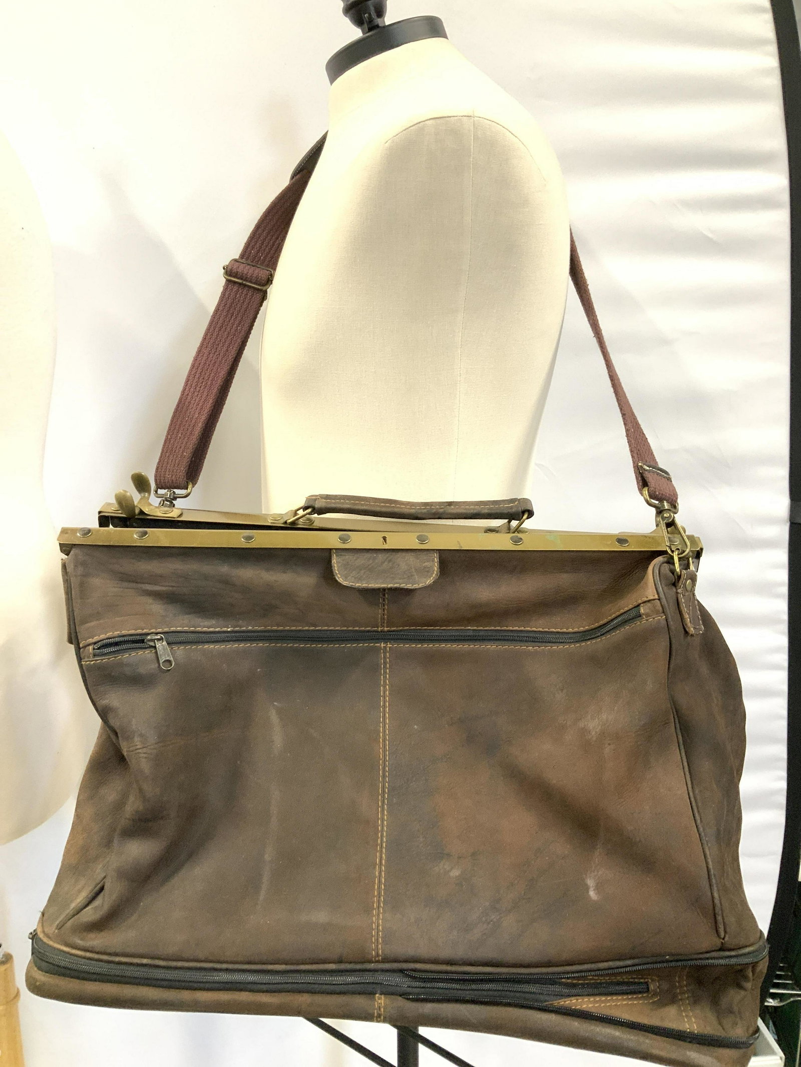 Brown Suede Crossbody Duffle Bag: Vintage brown suede duffel bag with metal frame and swivel latches. Weighted bag. Extends on the bottom, has exterior side zipper compartment , long cross body strap with leather shoulder pad. Carry h