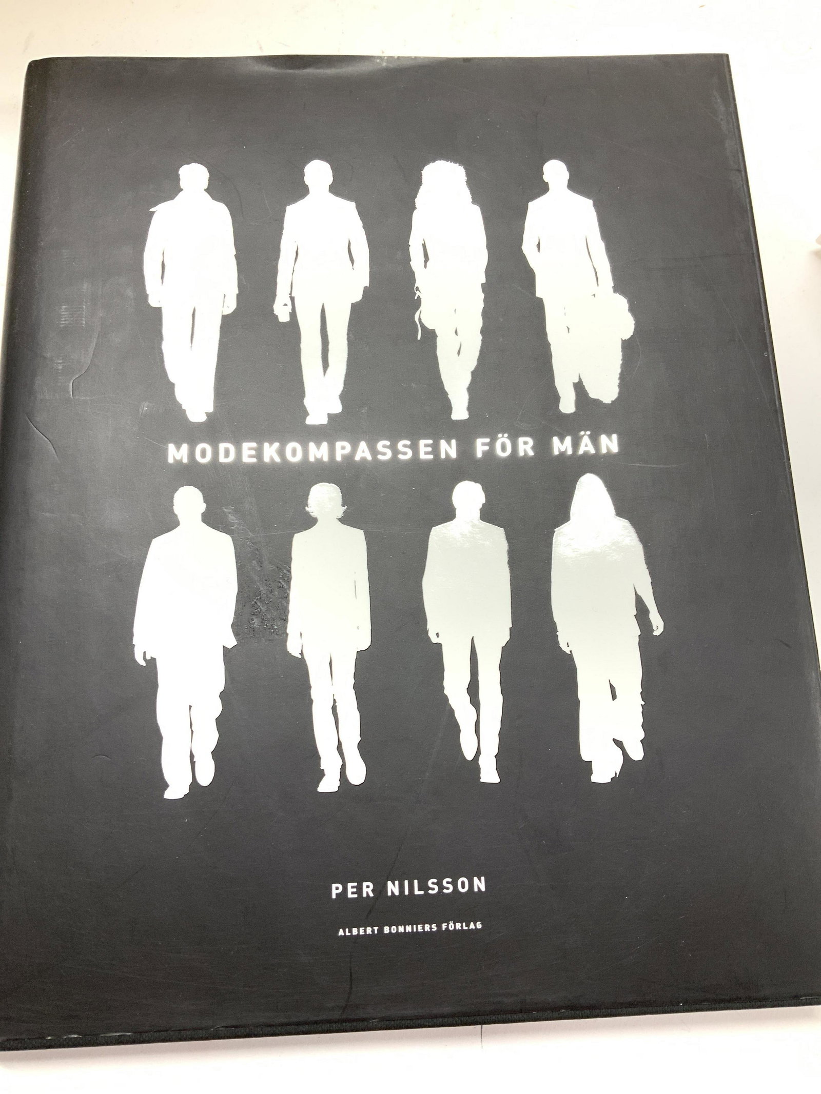 Fashion Designer Book in Swedish: Fashion Design Book in Swedish Language , title: MODEKOMASSEN FOR MAN by PER NILSSON. Albert Bonnies Forlag, Sweden c 2004 Measures 10.25 x 8 in. Colored photos of Runway, mens clothing featuring desi