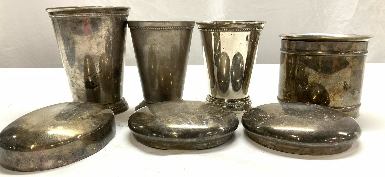 Silver Plated Kitchen Vessels , Lot 8: Silver plated vessel, many uses. Vintage pieces, no makers Mark. Up cycle for any use. Group 3 footed beverage vessels, large and taller measures 5 x 4 in. Marked MM round canister with lid, measures 