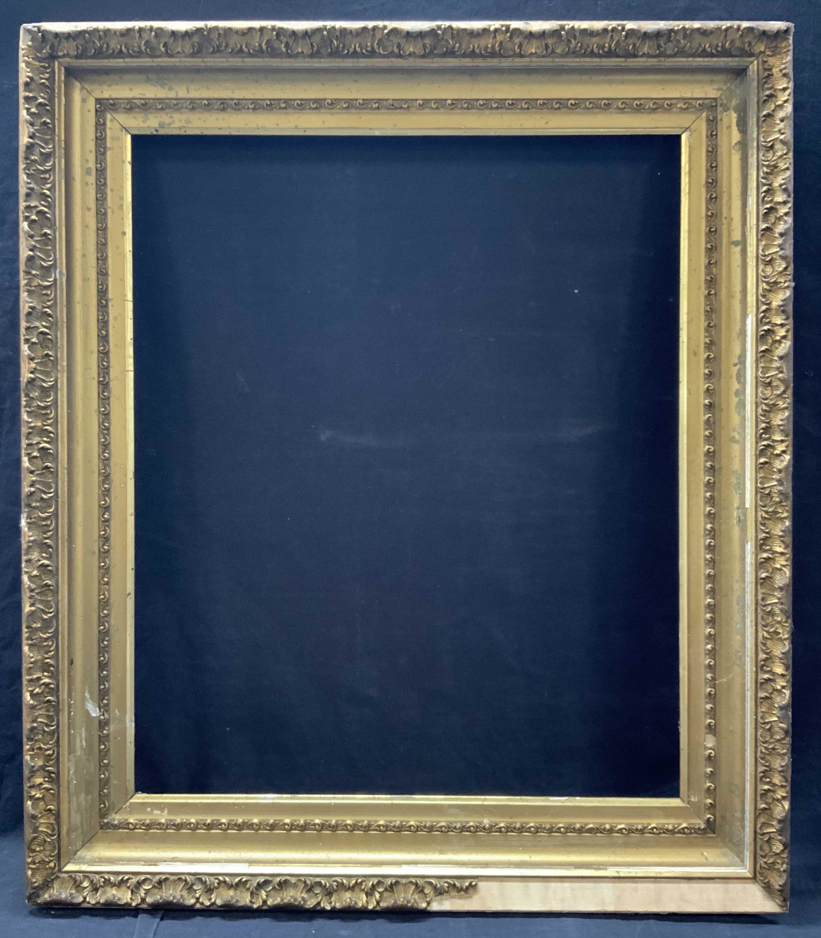 Ornate 23 x 19.5 Inch Gold Leafed Wooden Frame: Ornate wooden frame with raised scroll floral patterns on outer edges with gold leafing throughout. Inner edge is approximately 23.25 x 19.5 inches, outer edge is approximately 30 x 26 inches. Evident
