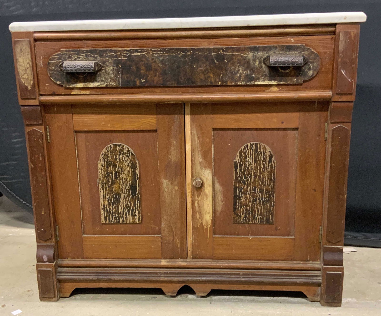 Vintage Wooden Marble Top Chest: Chest is vintage and wooden. Piece has white toned marble top. Chest has cabinet area and drawer. Drawer has ornate metal, possibly brass drawer pulls. Piece Measures approx 27 inches tall 31 inches l