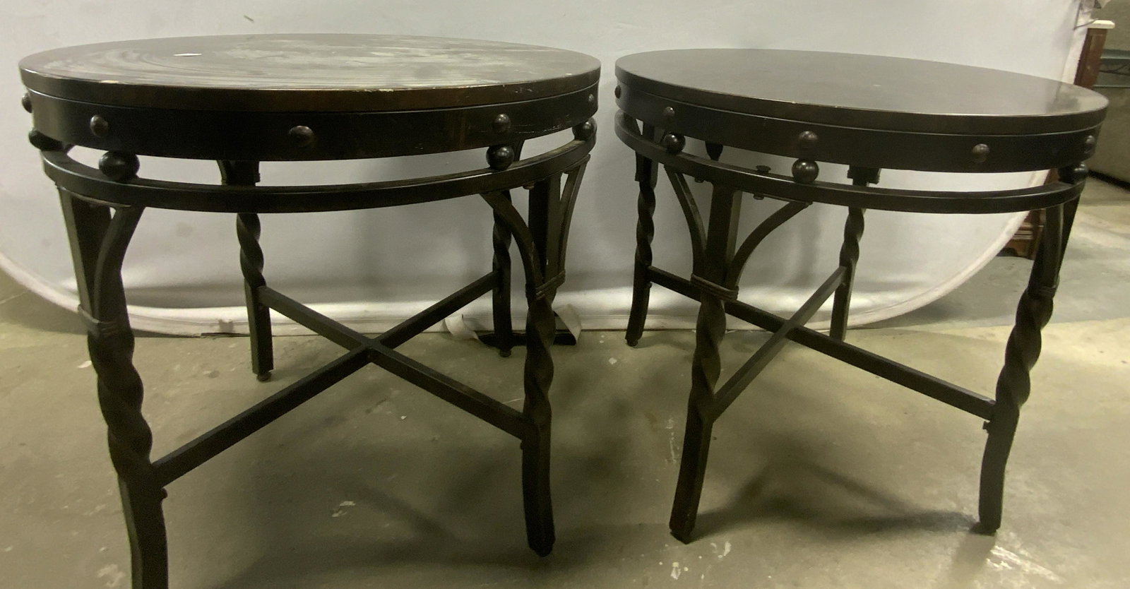 ASHELY FURNITURE Pr Metal Occasional Side Tables: Underside has tag which reads ASHLEY FURNITURE. Each piece is metal with circular shaped top. Tables have twisted metal legs with x shaped stretcher in between. Each piece Measures approx 23.5 inches 