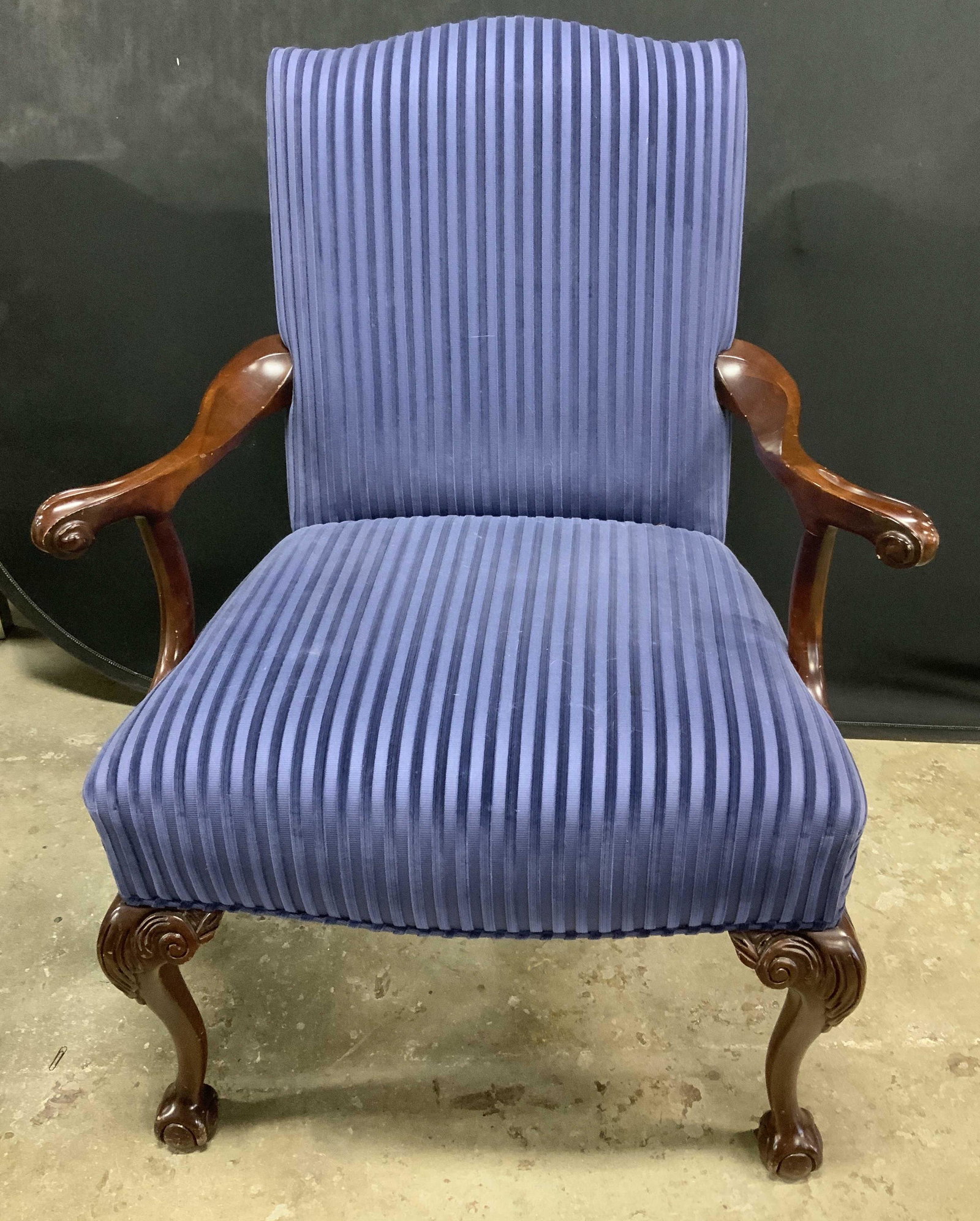 Blue Velvet Upholstered Queen Anne Arm Chair: Blue velvet upholstered arm chair with Queen Anne style carved wooden legs. In good condition, some surface wear consistent with exposure. Measures approx. 22.5 x 32 x 41 inches. Queen Anne style chai