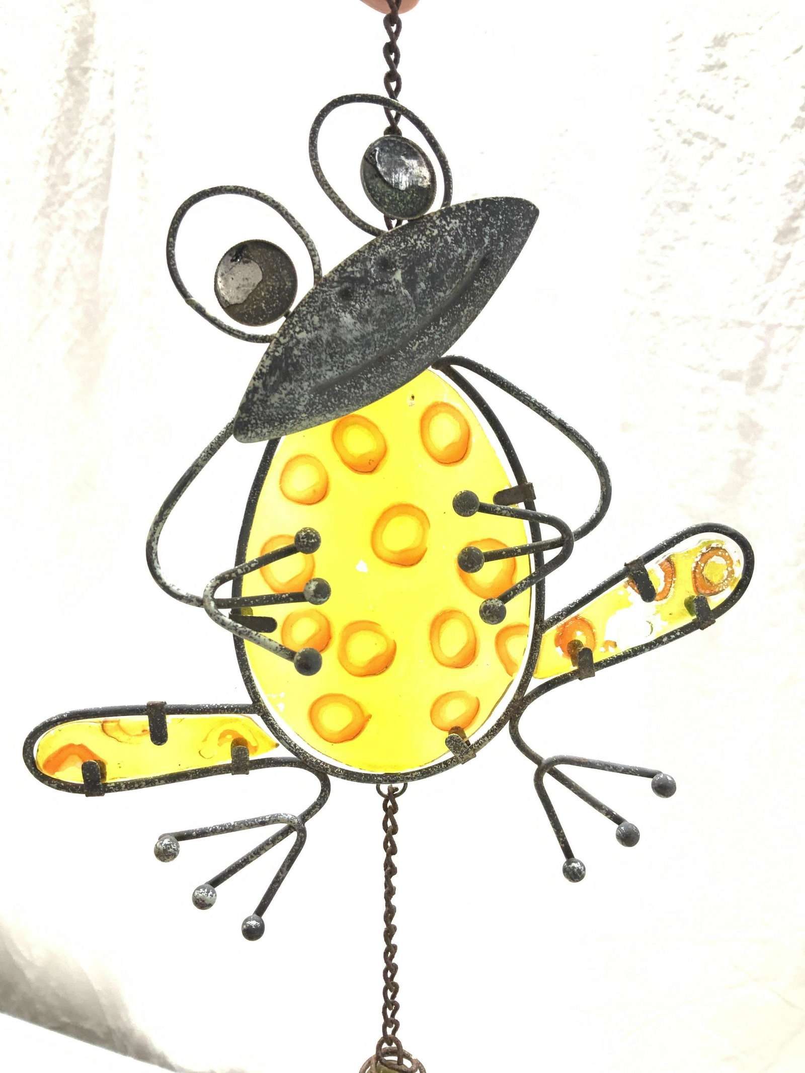 Artisanal Art Glass & Metal Frog Wind Chime: Arts and Crafts Frog motif wind chime, yellow glass with metal wire frog outlining shape. Attached hanging hook. Total length 30 in. Width 7.5 in. Ware to metal consistent with weather exposure. Very 
