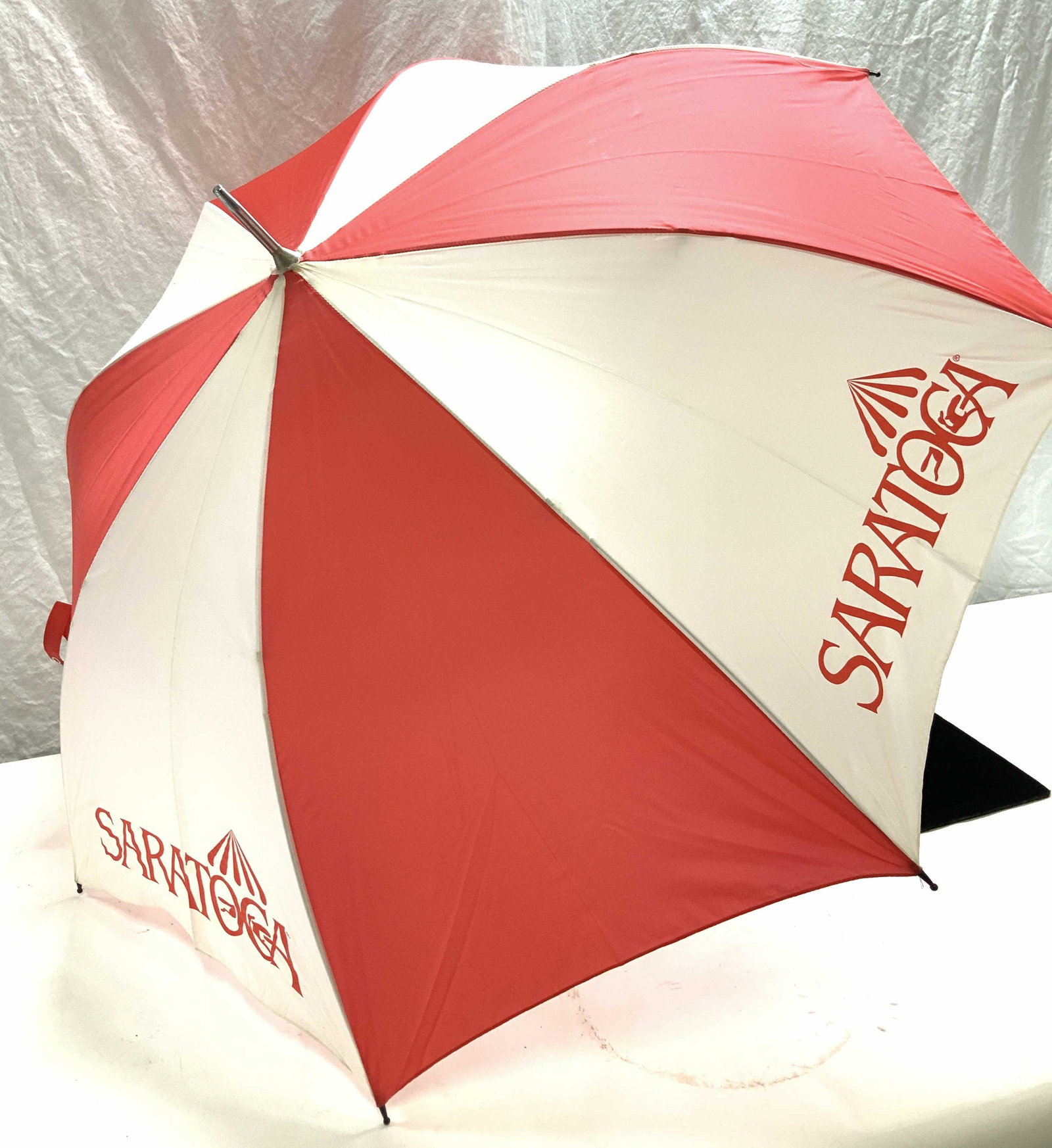 Saratoga Horse Handle Umbrella, New: Red and white Saratoga Springs Umbrella with race horse handle. Total length 34 in. L. Width 40 in. Umbrella reads SARATOGA. Horse handle is 4 in. wide. Saratoga Umbrella, race horse handle umbrella, 