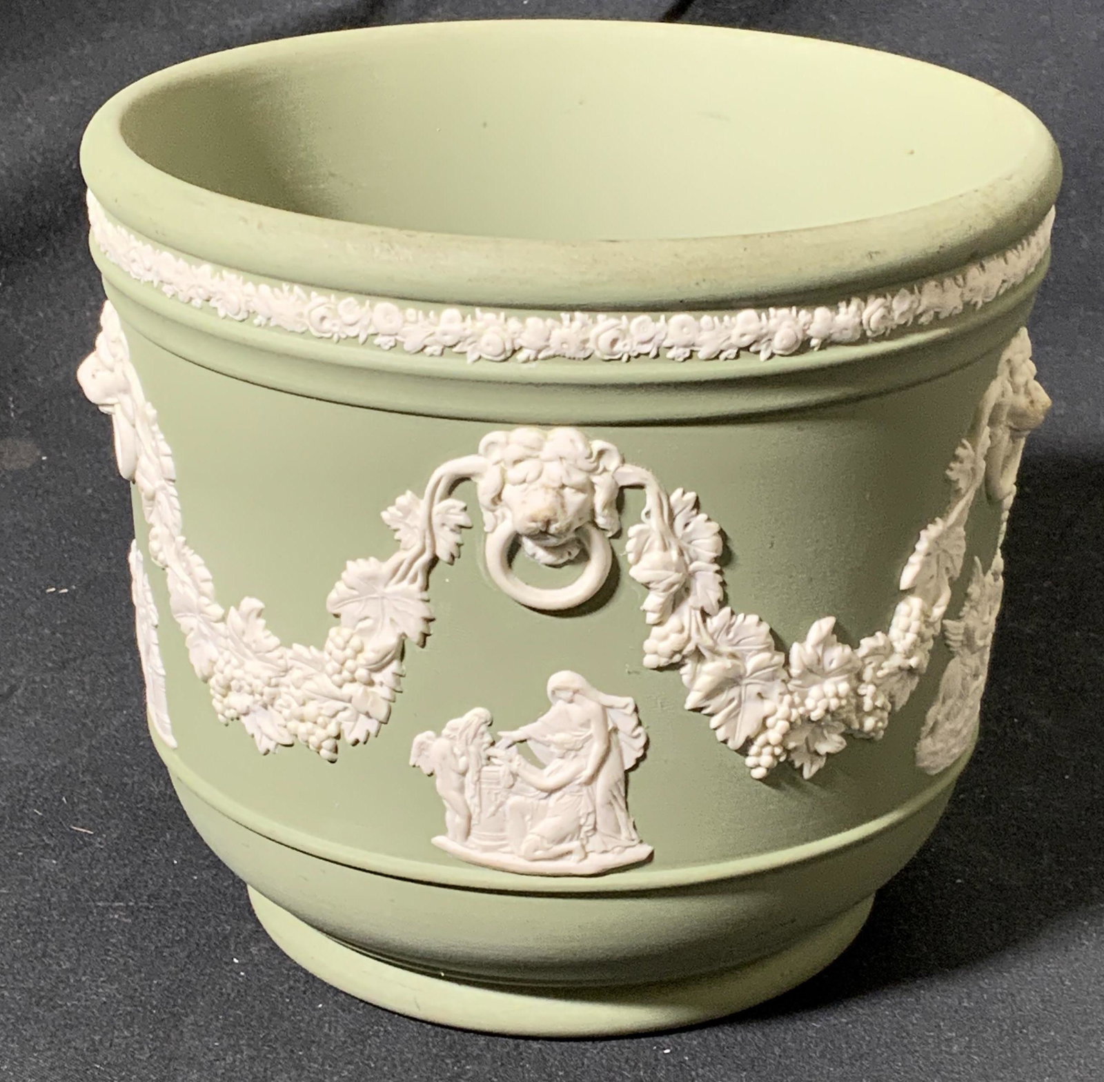 WEDGWOOD Sage Jasperware Cachepot: Wedgwood signed sage green Jasperware Cachepot with white figural relief. Measures approx. 4.75 inches diameter and 4.5 inches tall. Some surface wear constant with exposure. Trademarked to underside.