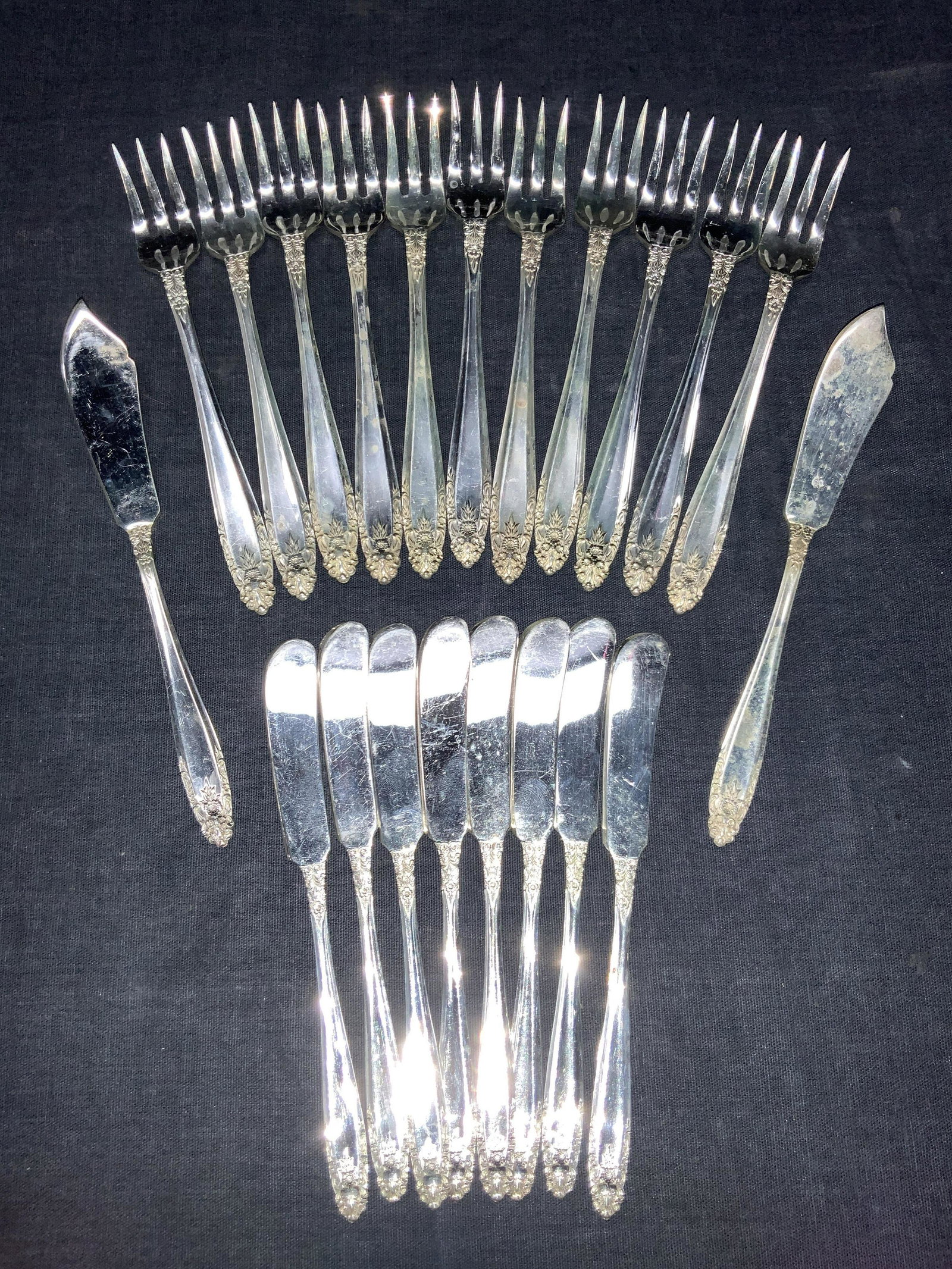 Set21 Nickel Silver Cocktail Utensils: Set of 21 cocktail utensils. 11 three prong cocktail forks 2 cheese knives 8 butter knives All marked Nickel Silver on backsides with ornate floral designs on handles. Approximately 5.75 inches long. 