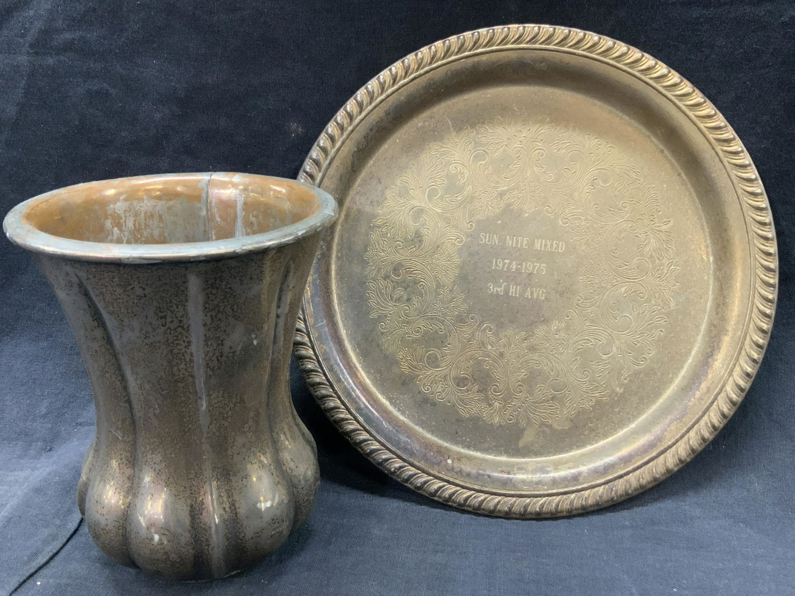 2 Silver Plate Engraved Table Accessories: Group lot of 2 white metal accessories. 1 goblet with vertical grooves going down the body. 5 inches tall and 4.5 inch diameter 1 etched and engraved plate with embossed edges, 8 inch diameter. Goblet