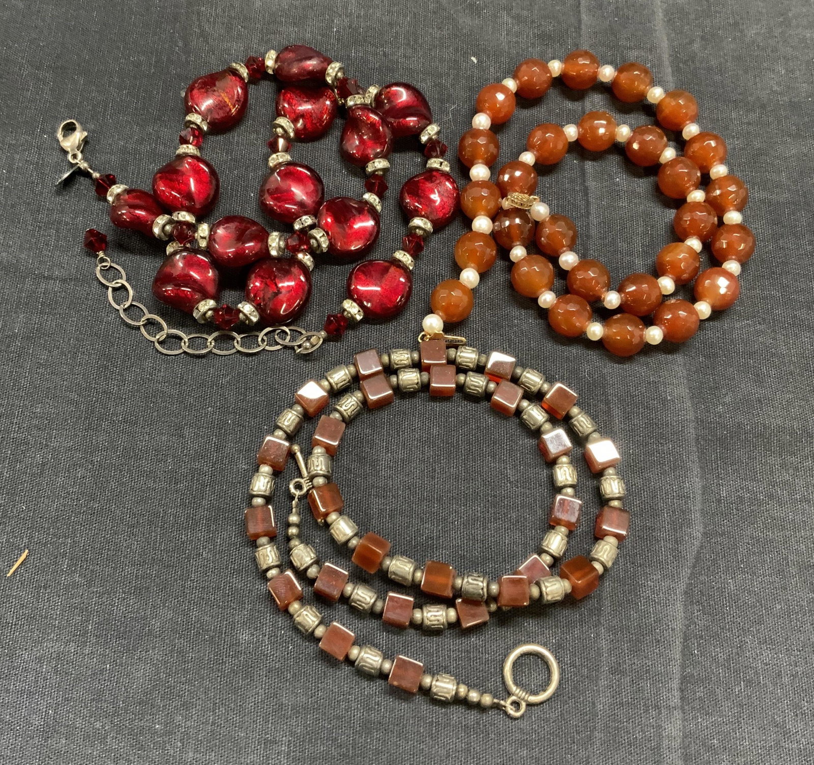 Lot 3 Pearl & Carnelian Beaded Choker, More: Lot of 3 necklaces. 1 natural pearl and faceted carnelian beaded choker necklace with 10k Gold clasp. Marked 10k on clasp. Measures approx. 15.5 inches long. 1 Lucky Clover red costume beaded necklace