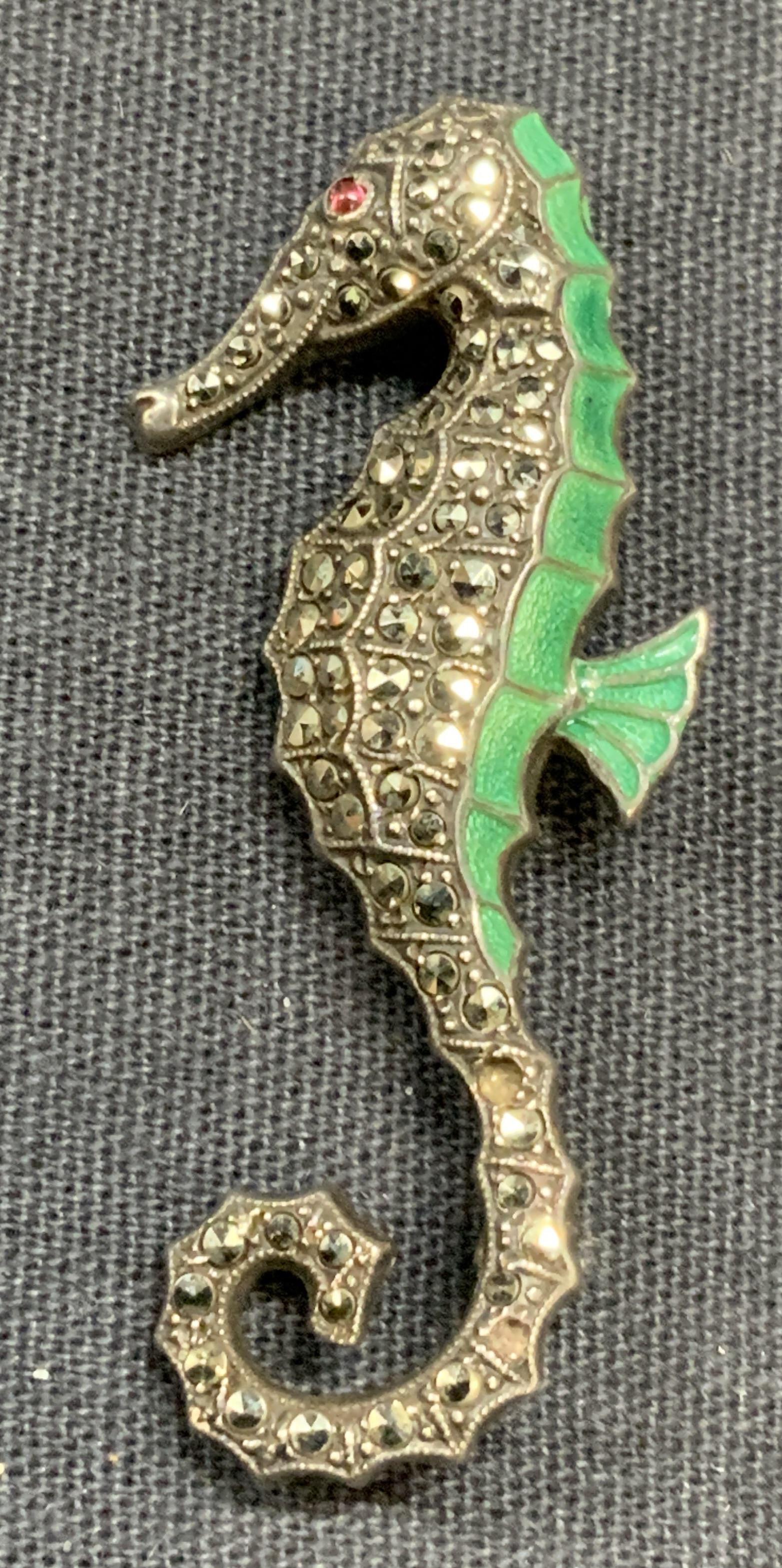 Sterling silver & Marcasite Seahorse Brooch USA: Sterling silver and marcasite seahorse brooch. Marked sterling, made in USA to underside. Hinge pin to underside. Measures approx. 1.75 x .75 inches. Some surface wear consistent with exposure. Total 