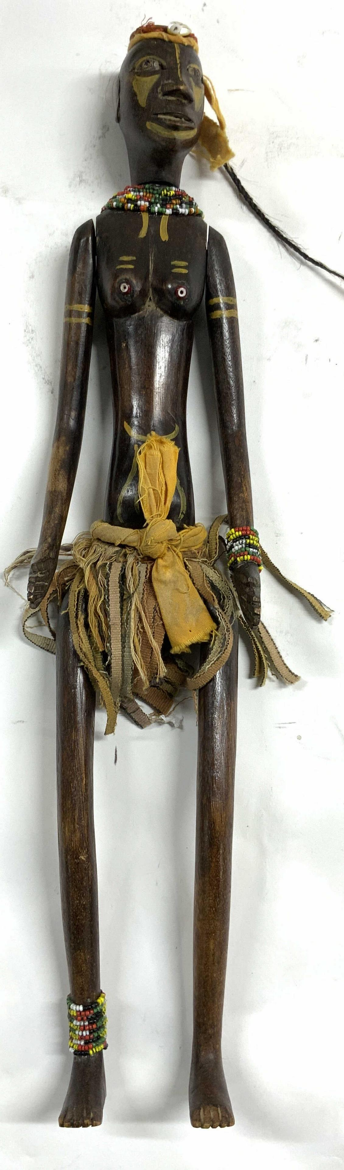 Vtg HandMade Marionette Wooden African Hand Doll: Marionette is vintage and wooden. Piece depicts partial nude female figure. Piece is articulated with movable arms, legs, & head. Marionette has cloth and beaded detail. Piece measures approx 19.5 inc