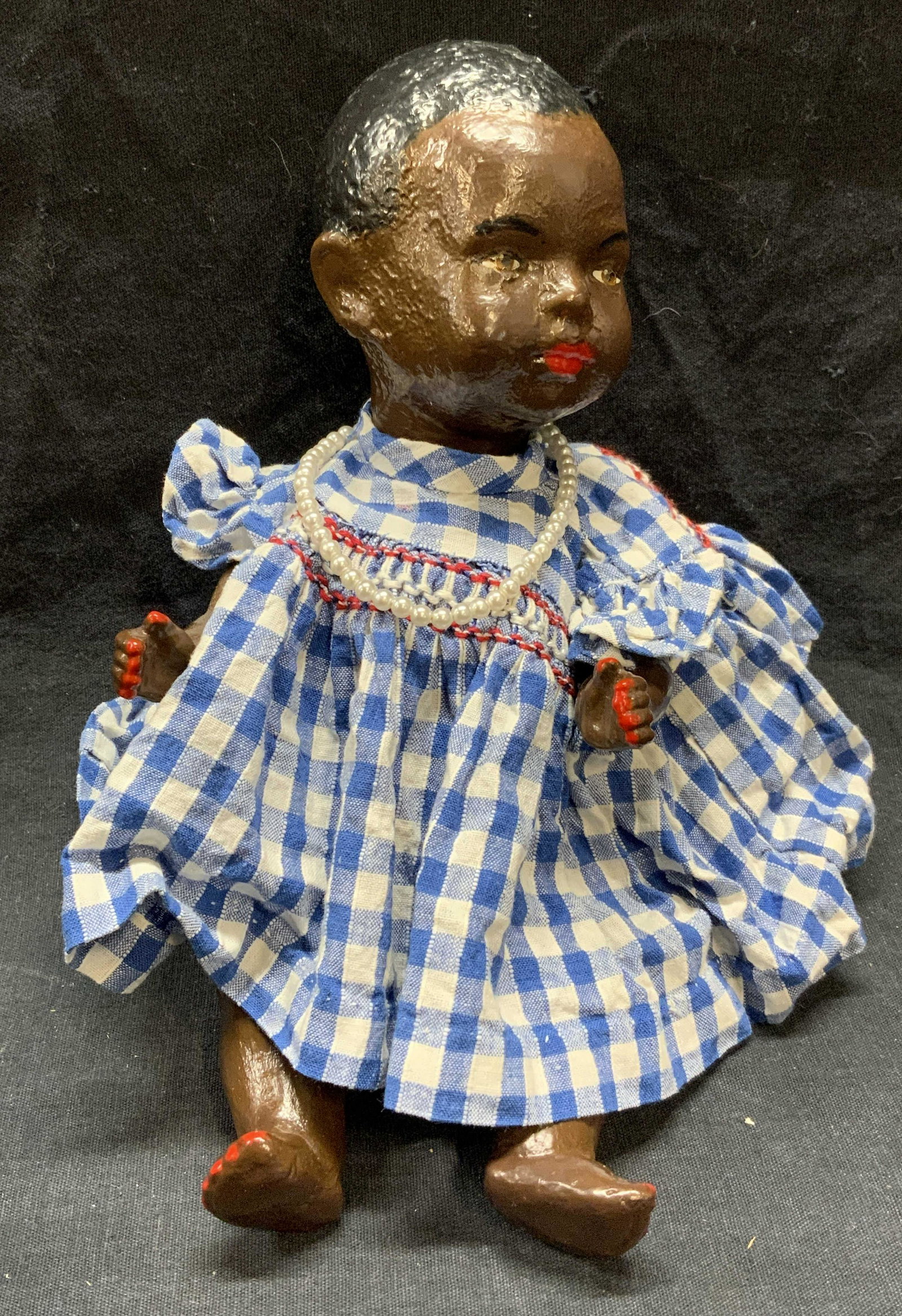 Vintage Hand Painted Baby Doll: Vintage hand painted baby doll with gingham top and shorts and faux pearl necklace marked Japan. Possibly cast plaster. Measures approx. 9 x 4 x 4 inches. Some surface wear consistent with exposure. B