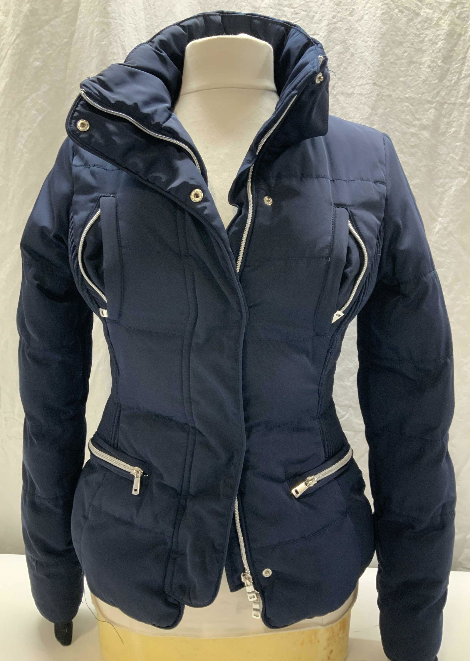 Horze Crescendo Equine Winter Jacket: Navy blue polyester jacket by designer Horze Crescendo. Size 6 ladies. Multiple zipper pockets on frontside. Zippers and snaps closed. Poly fill for warmth. Light wear. Equine jacket, equestrian jacke