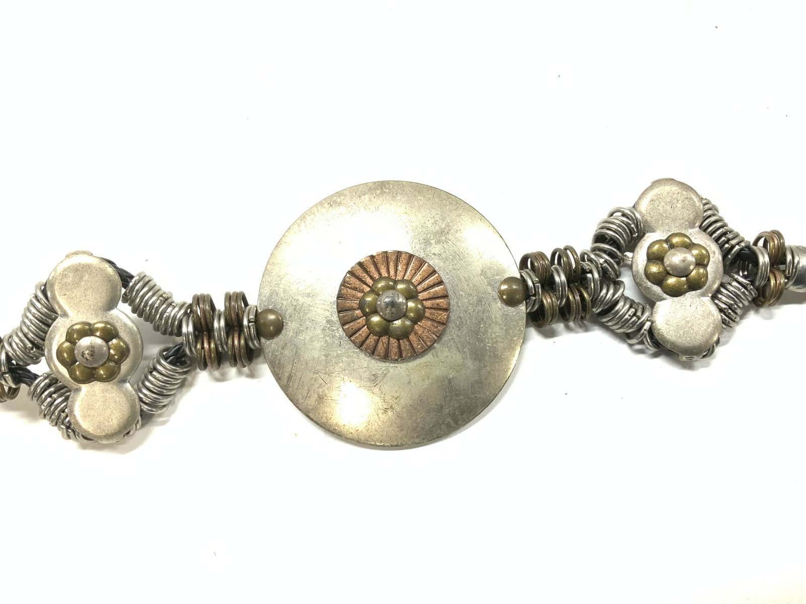Hand Crafted Chicos Metal Belt: Signed Vintage Chicos Metal Steampunk belt with heavy center metal medallion using silver tone metal, brass tone and copper tone as embellishment. Centerpiece measures 4.5 in. diameter . Black Braided