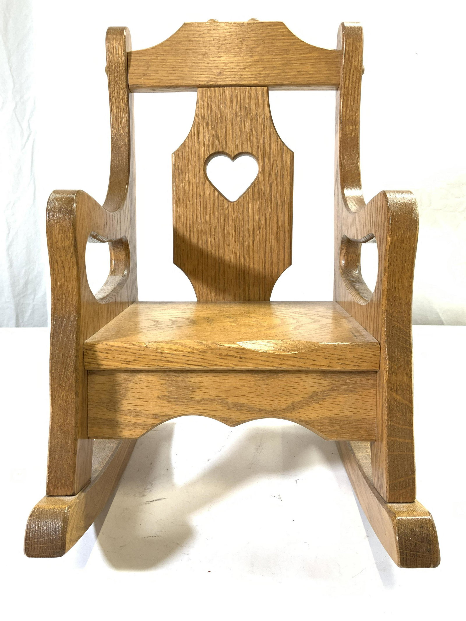 Vintage Wooden Doll Rocking Chair: Rocking chair is vintage and wooden. Piece is doll size. Chair is tan toned with pierced heart shape in center of backrest. Piece measures approx 15 inches tall 9.5 inches wide 14 inches deep. Doll Ch