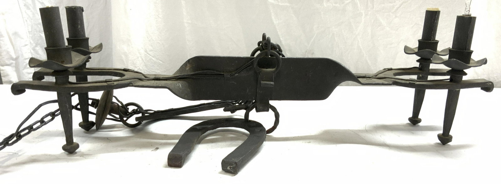 Vtg 4 Arm Iron Chandelier W Horseshoe Structures: Chandelier is vintage possibly antique. Piece is iron. Chandelier has horseshoe structures and long chain link. Piece has 4 arms. Chandelier measures approx 27.5 inches long 6.5 inches deep. Chain on 