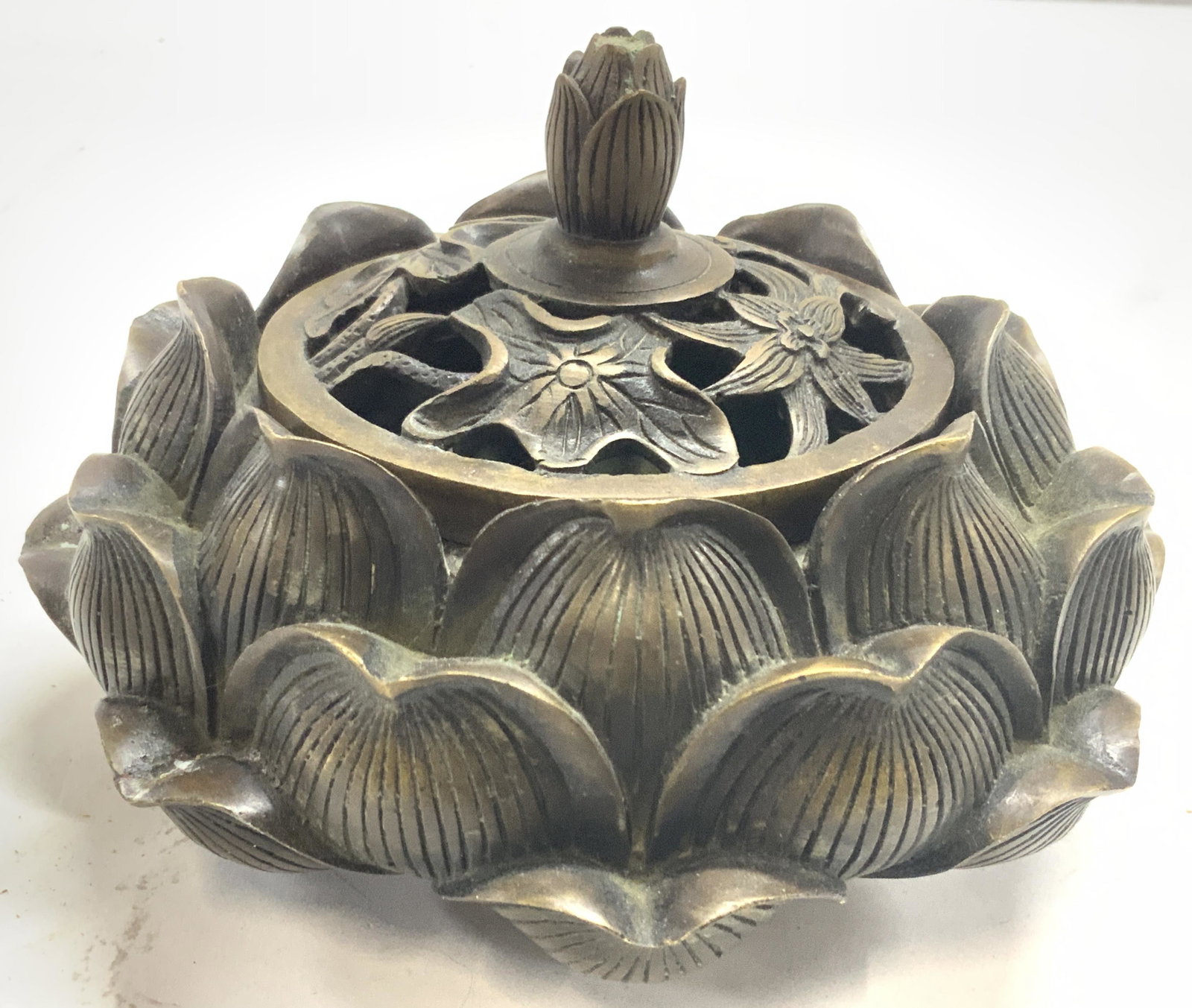 Stamped Asian Bronze Lotus Censer: Asian lotus censer, incenser possibly made of bronze or other non magnetic metal. Body of incenser resembles a lotus flower with lid having cut outs with floral motifs. Evident loss to handle of lid. 
