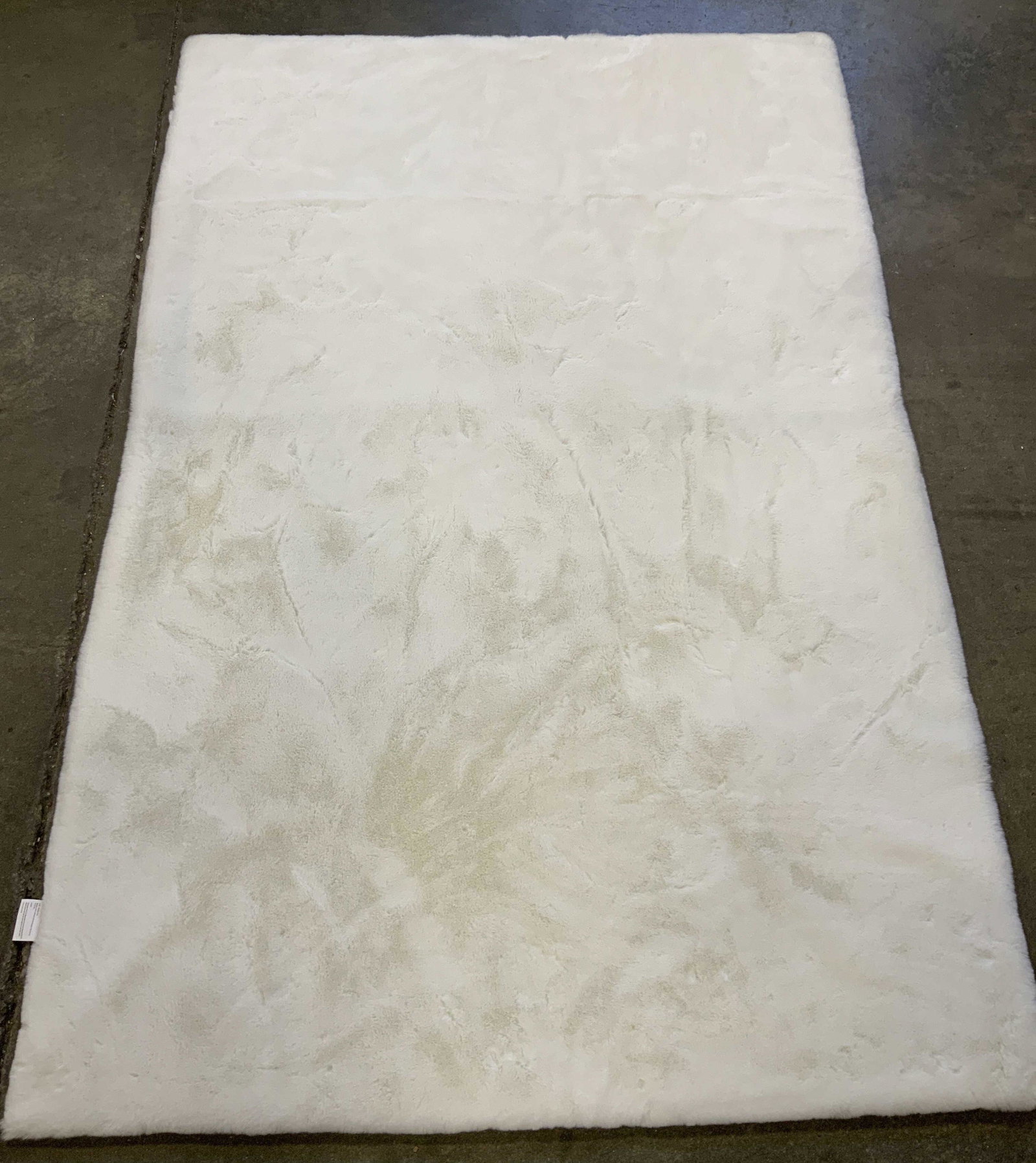 Silhouette Home Faux Fur Accent Rug: Marked in underside with tag that reads Silhouette Home Rug, 100% Polyester. 4ft x 6ft 122cm x 180cm White faux fur with suede style underside. Minor discoloration due to dust Silhouette home accents 