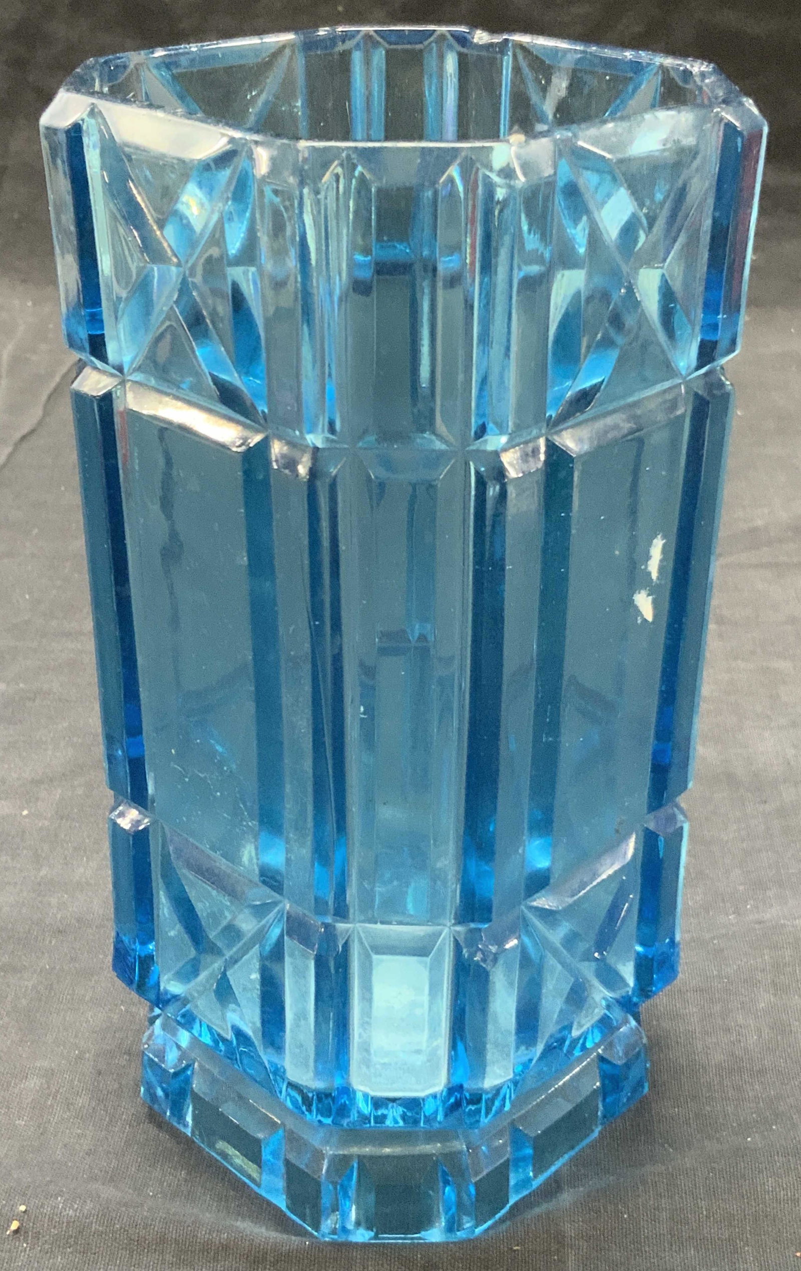 Vintage Blue Toned Cut Art Glass Vase: Vintage blue toned glass vase in a square shape with x cut grooves with art deco vertical cuts. Approximately 7 inches tall and 3.25 inch diameter, Evident loss to edges. Vintage glass vase, glass vas