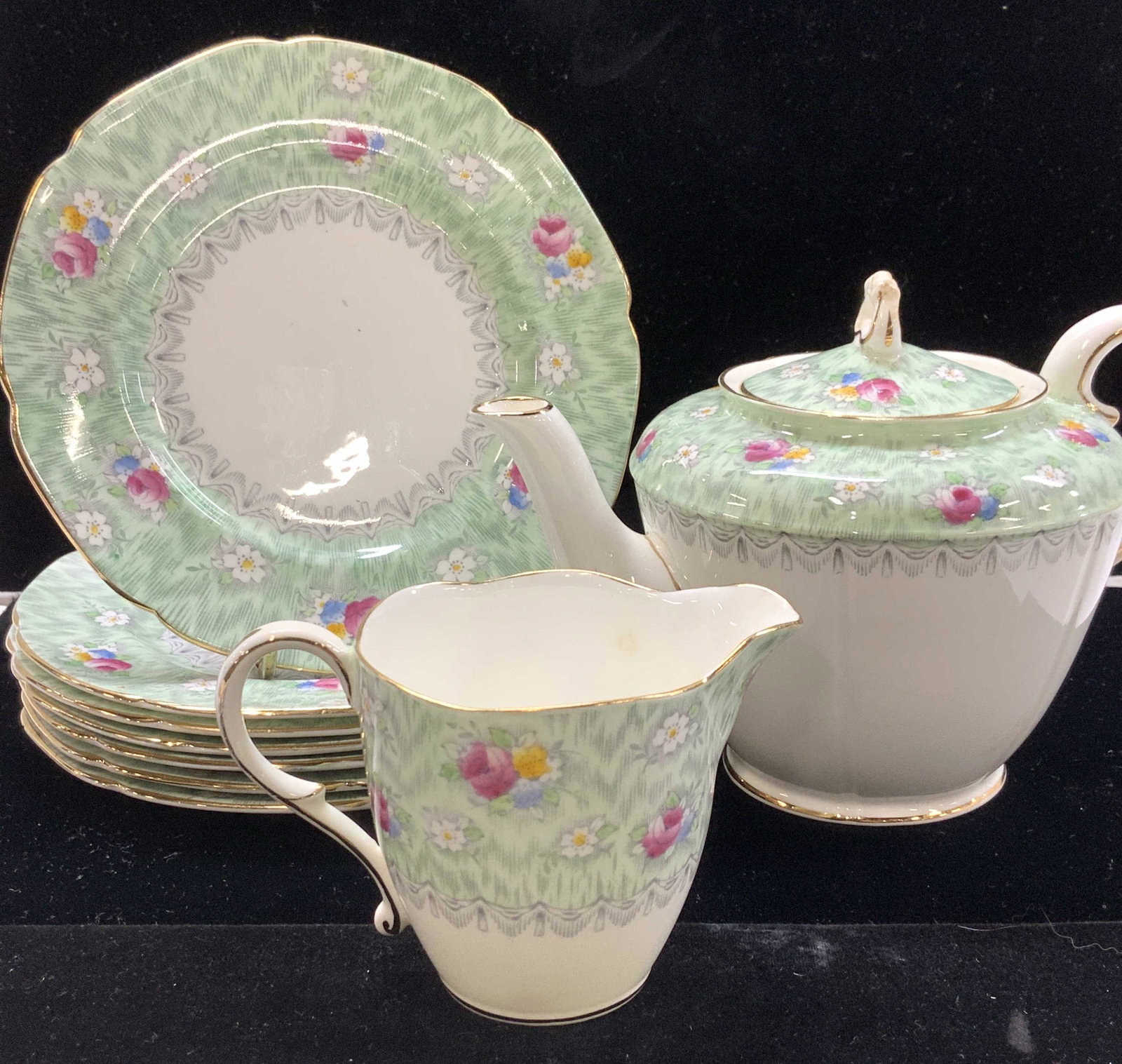 Paragon Evangeline China Tea Set 9, England: Paragon Evangeline Fine Bone China manufactured for Simpsons Montreal, c. 1932-1939 Made in England. Teapot with lid, Creamer, 7 dessert plates , one with underside chip. Tea pot measures 7.5 x 5 x 4 