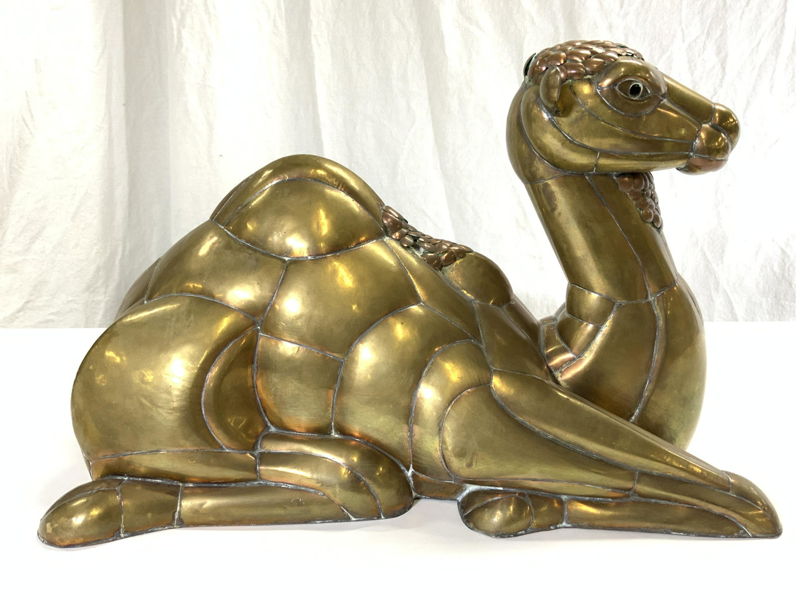 SERGIO BUSTAMANTE ATTR Gilt Copper Camel Figure: Camel figure is gilt copper Attr SERGIO BUSTAMANTE 1934-2014 MEXICO, no hallmarks or signatures observed. Depicts a seated camel figure Measures approx 16.5 inches deep 11.5 inches tall 10.5 inches wi