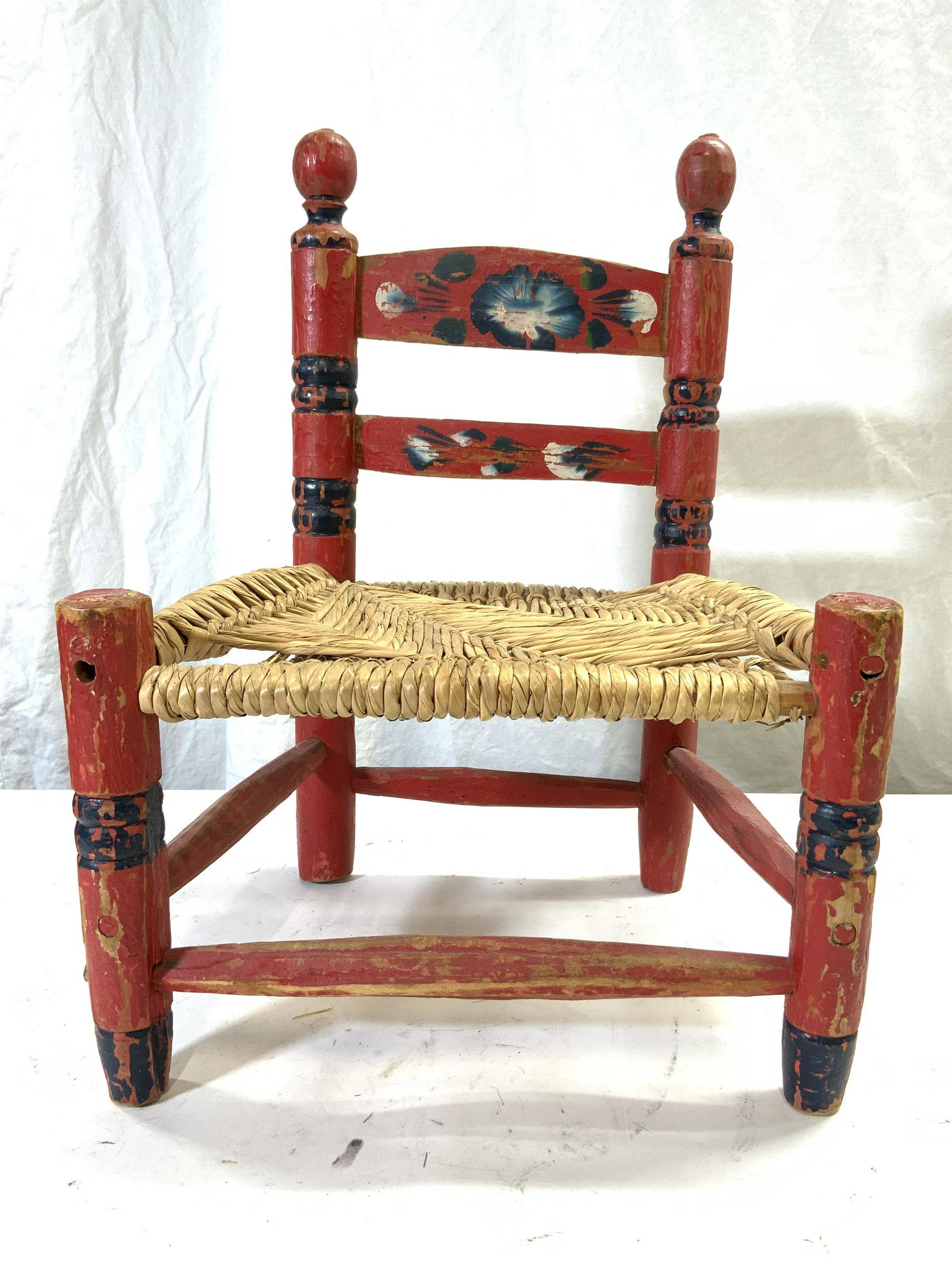 Vntg Hand Crafted Wooden Doll Chair Red MEXICO: Backside is marked for MEXICO.Doll chair is red toned and wooden. Piece is vintage possibly antique. Chair appears to be hand crafted and hand painted with floral detail. Legs have Box shaped stretche