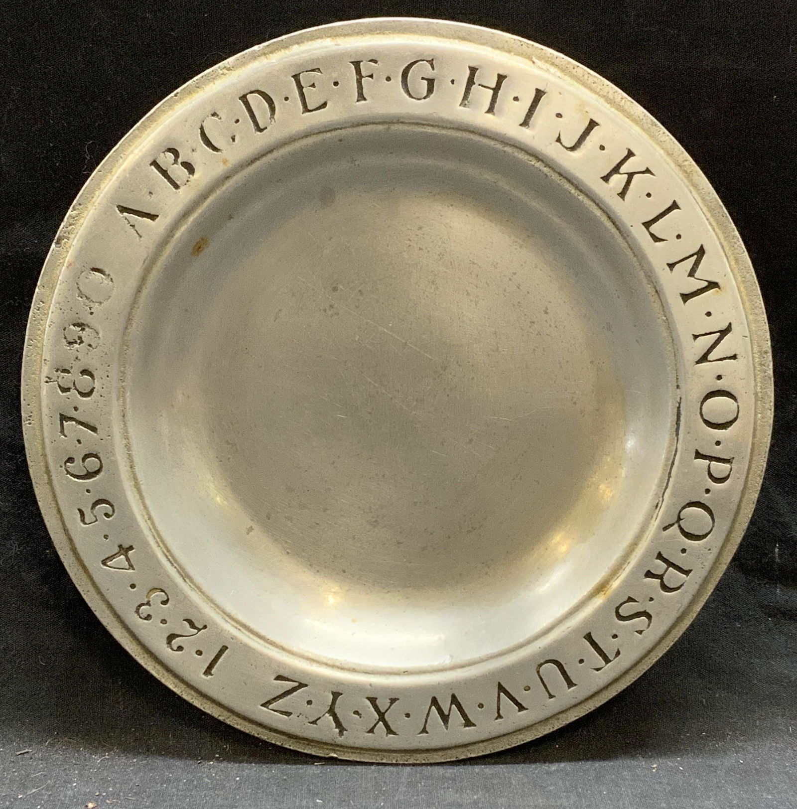 RWP WILTON Pewter Alphabet & Numbers Plate: RWP Wilton pewter plate with embossed alphabet and number decoration on rim. Trademarked to underside. Surface wear consistent with exposure. Measures approx. 9 1/8 inches diameter. RWP Wilton, RWP Wi