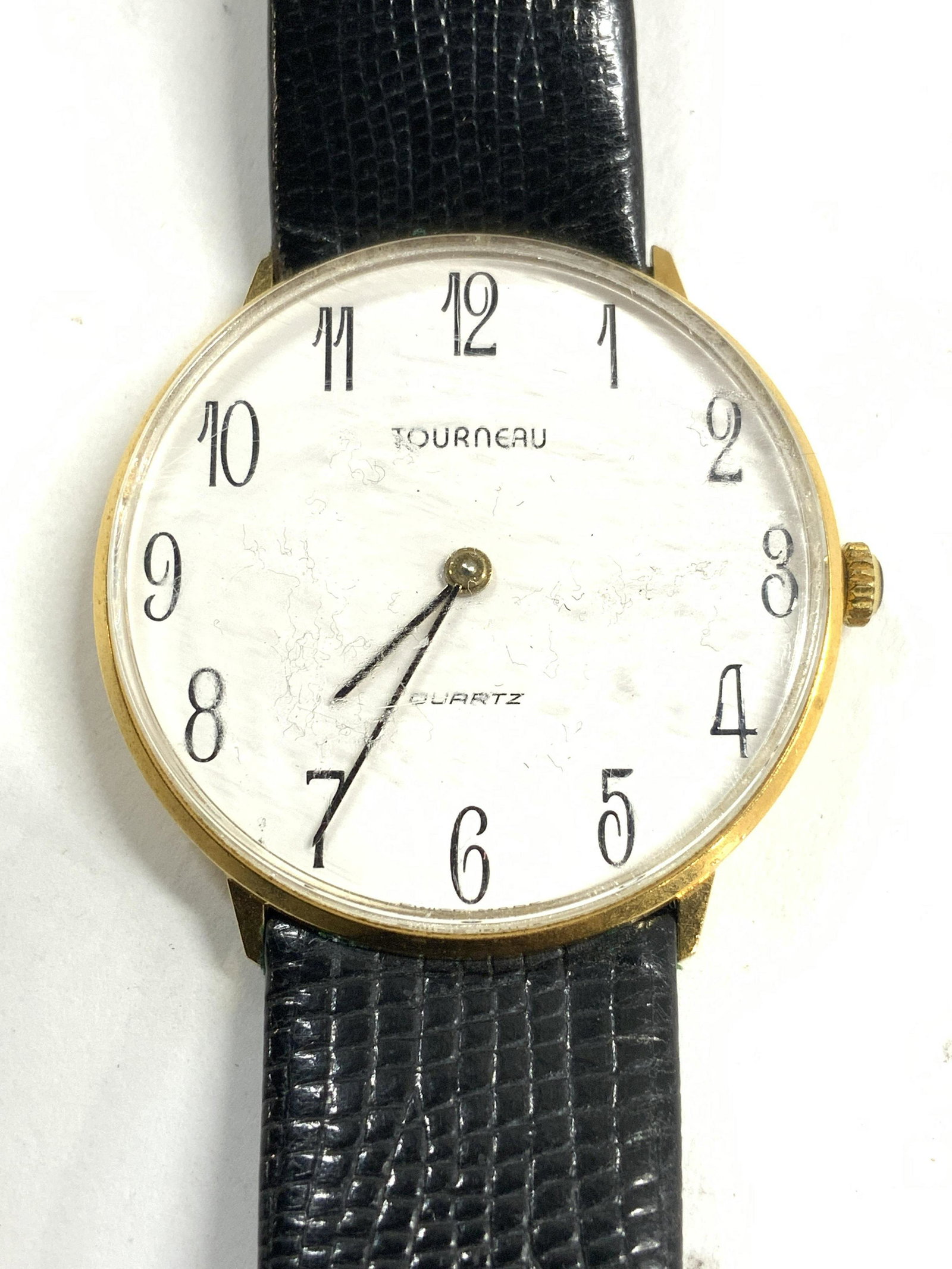 TOURNEAU Leather Band Watch: Watch face reads TOURNEAU. Piece has black toned croc leather style wristband. Watch face is white with black numbers & lettering. Measures approx 8.5 inches long 1.5 inches wide. TOURNEAU watch, leat